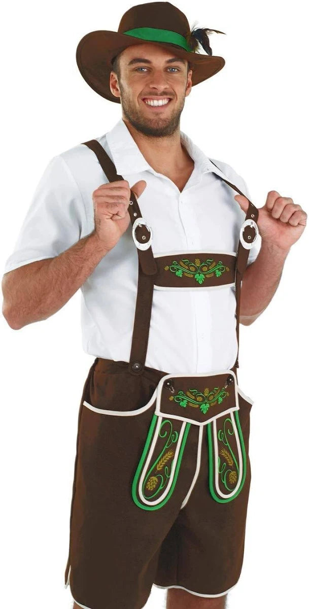 A man smiling while wearing a Bavarian fancy dress costume, featuring a white short-sleeved shirt, brown lederhosen with green hops and wheat embroidery on the chest piece and shorts flaps, and a brown alpine hat with a green band and feather.