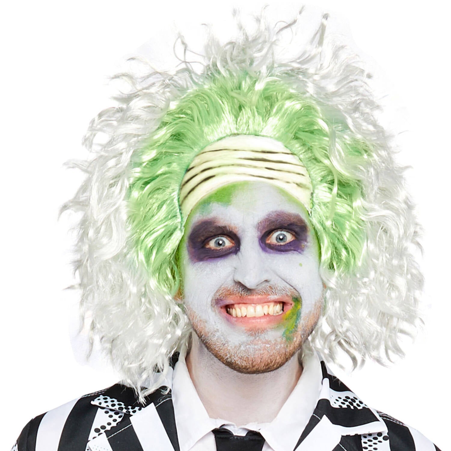 A man smiling a crazy smile wearing a Beetlejuice fancy dress wig featuring wild frizzy white hair, neon green roots, and an attached pale wrinkled forehead, paired with pale face paint and dark eye makeup.