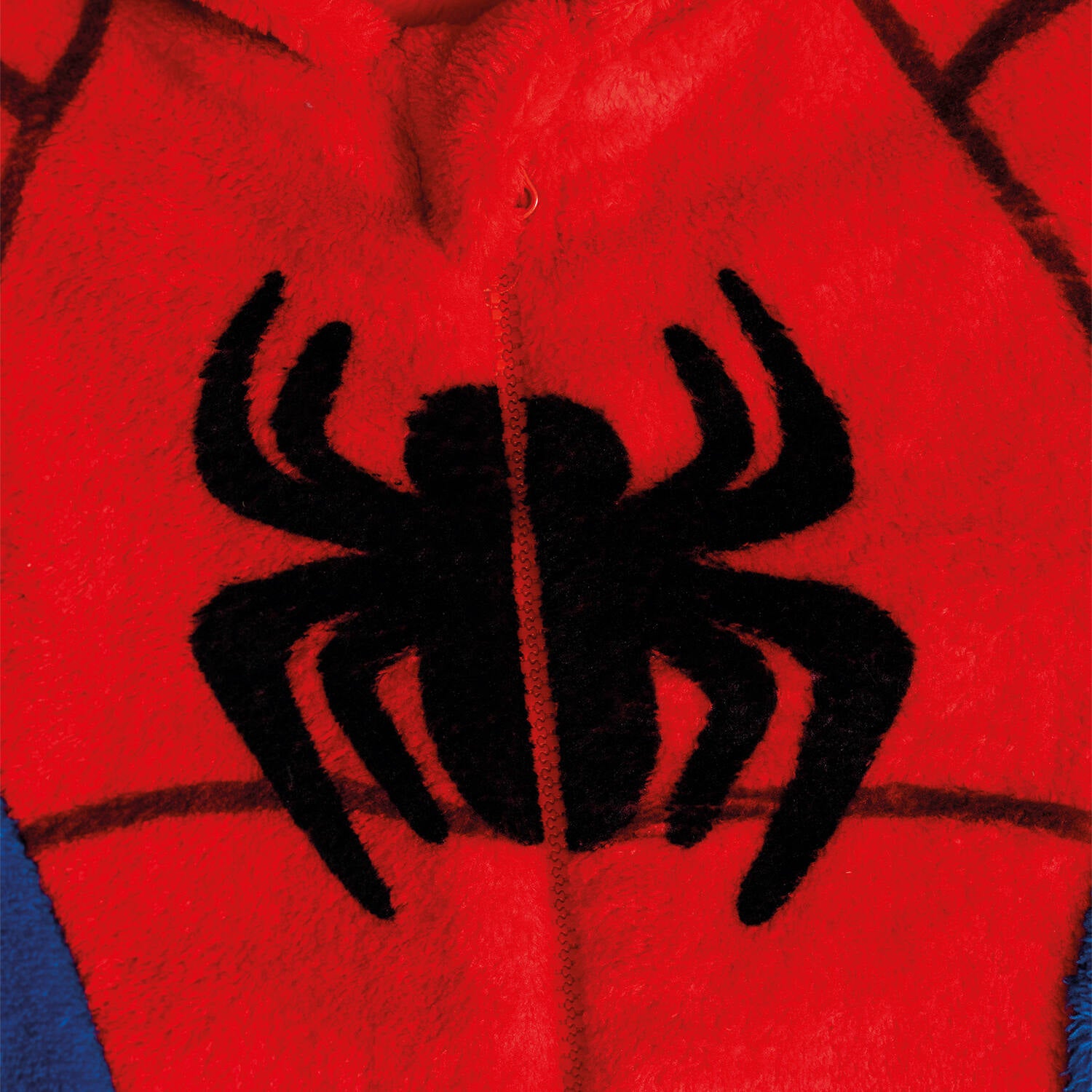 A close-up view of the black printed spider logo and the front zipper on the plush red chest of a children's Spider-Man onesie.