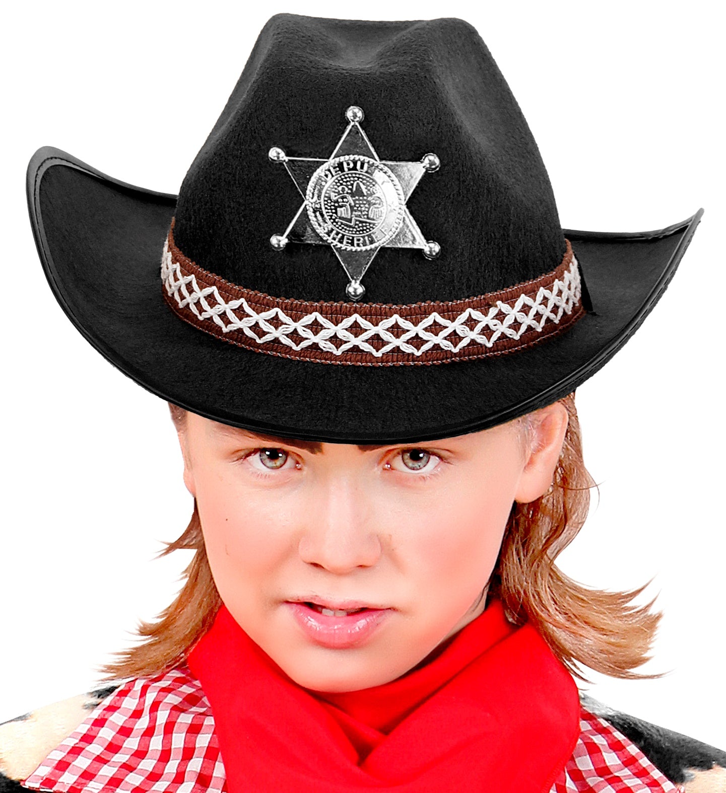A close-up of a boy wearing a black cowboy hat adorned with a silver sheriff's star badge and a decorative brown and white band, with a red bandana around their neck and a plaid shirt visible