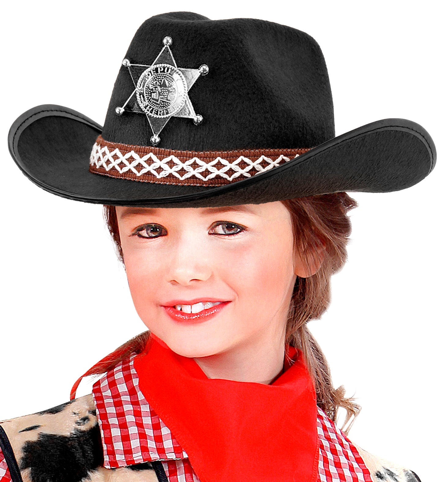 A close-up of a smiling girl wearing a black cowboy hat adorned with a silver sheriff's star badge and a decorative brown and white band, along with a red bandana and a plaid shirt.
