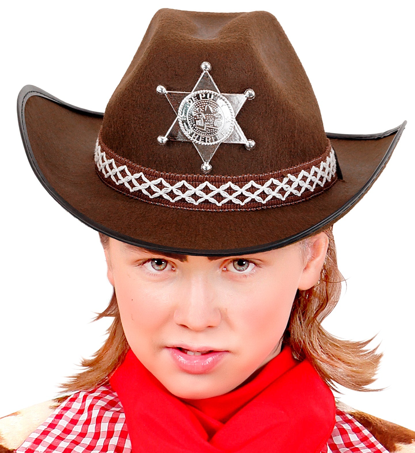 A close-up of a child wearing a brown cowboy hat adorned with a silver sheriff's star badge and a decorative band, with a red bandana around their neck and a plaid shirt visible.