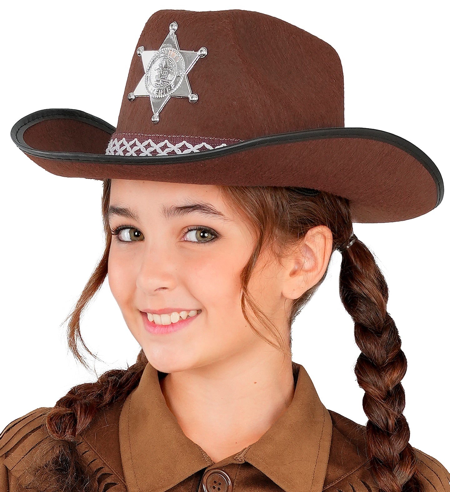 A close-up of a smiling girl wearing a brown cowboy hat adorned with a silver sheriff's star badge and a decorative band. The child has long braided hair and is wearing a brown fringed top.