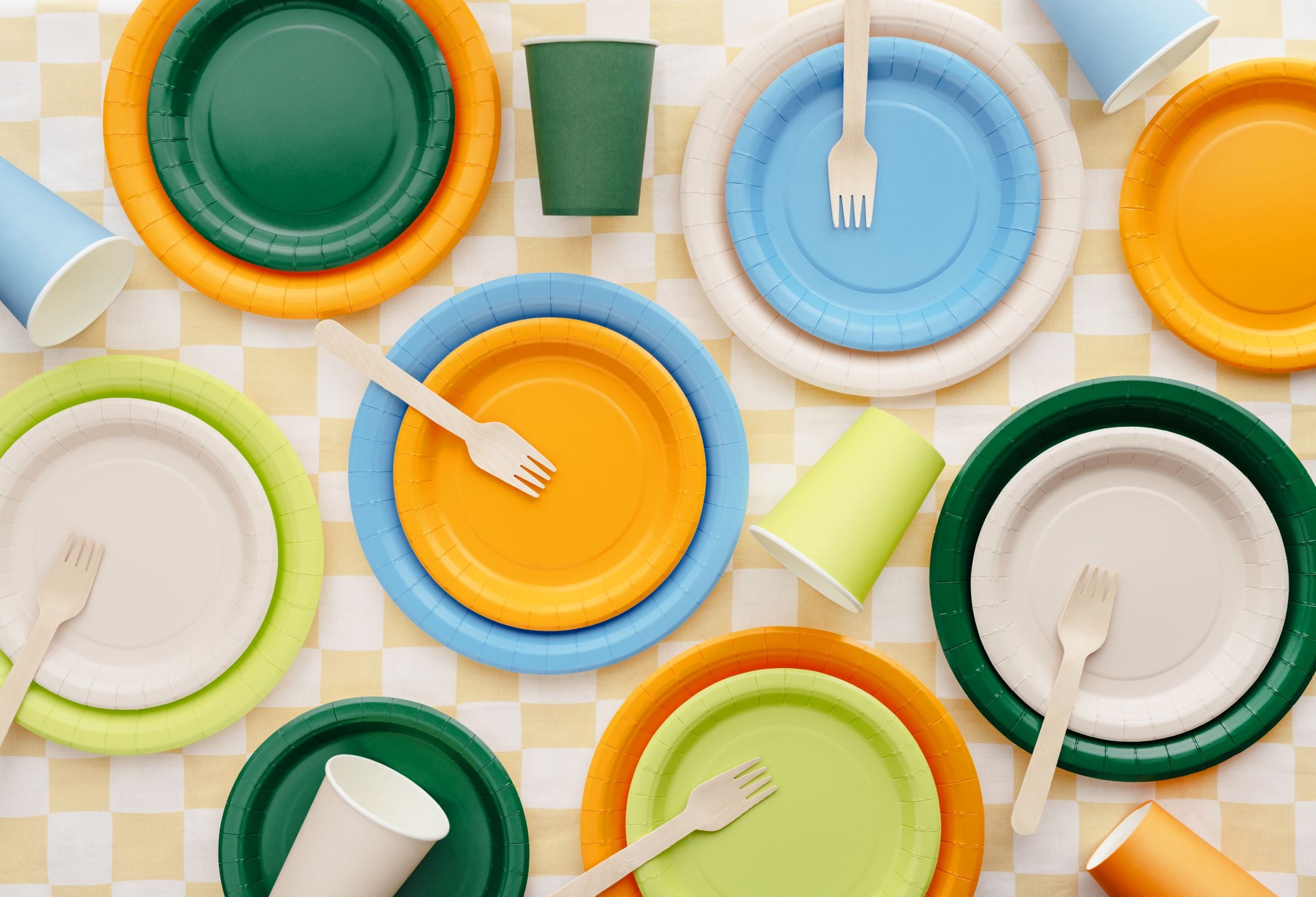 A party flat lay showing various colored plates, including dark green, arranged for a celebration