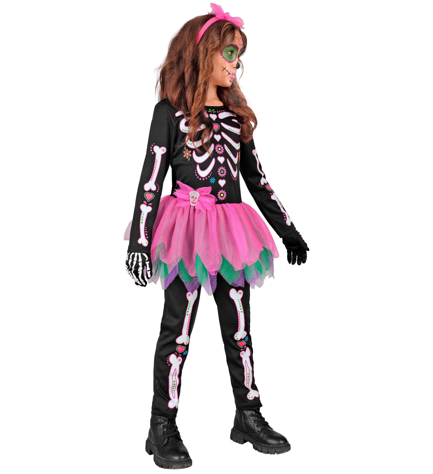 A side profile of a child in a Day of the Dead skeleton costume, showing the side of the black jumpsuit with colorful skeleton bones, a pink and green tutu skirt, and a pink floral headband.