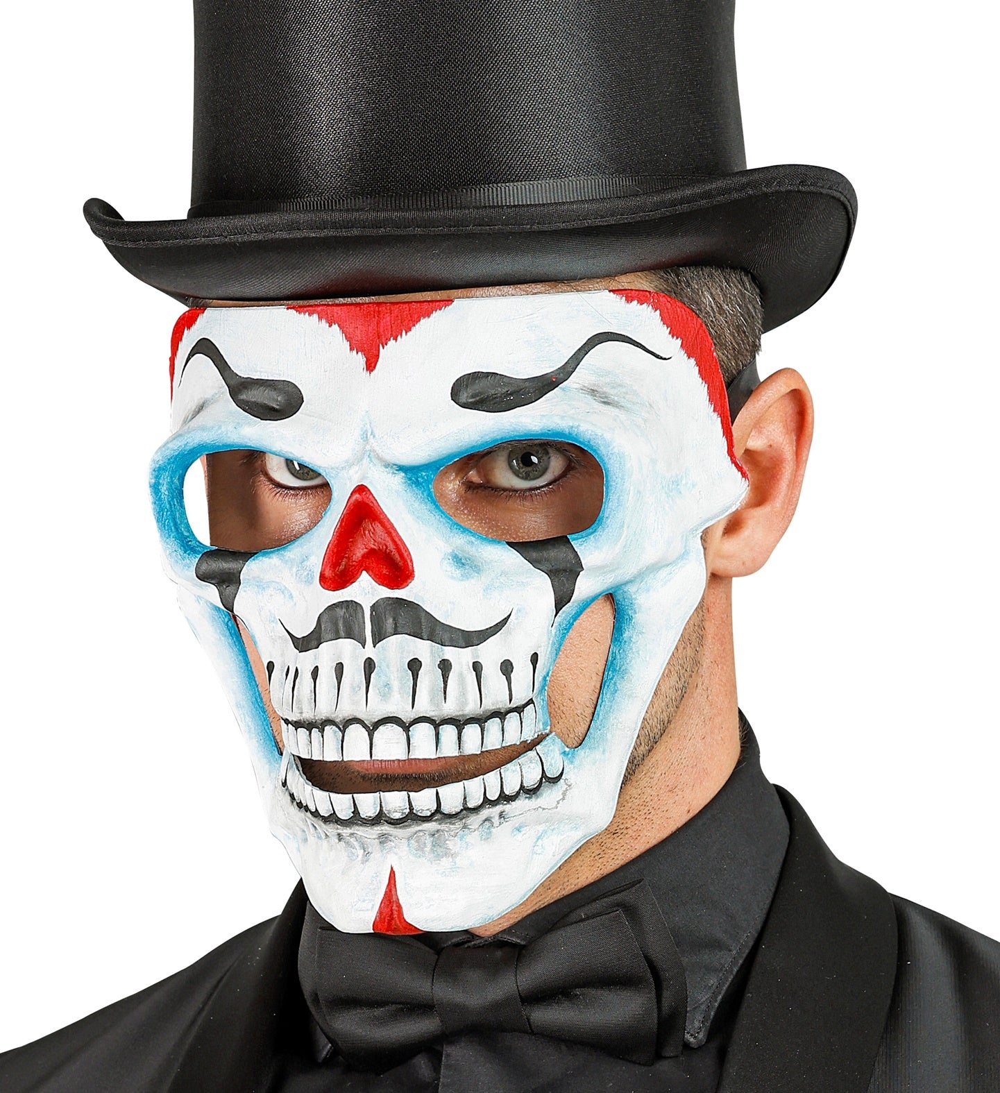 A man wearing a black top hat and bow tie looks forward through a white skull mask decorated with red, blue, and black clown-like makeup details.