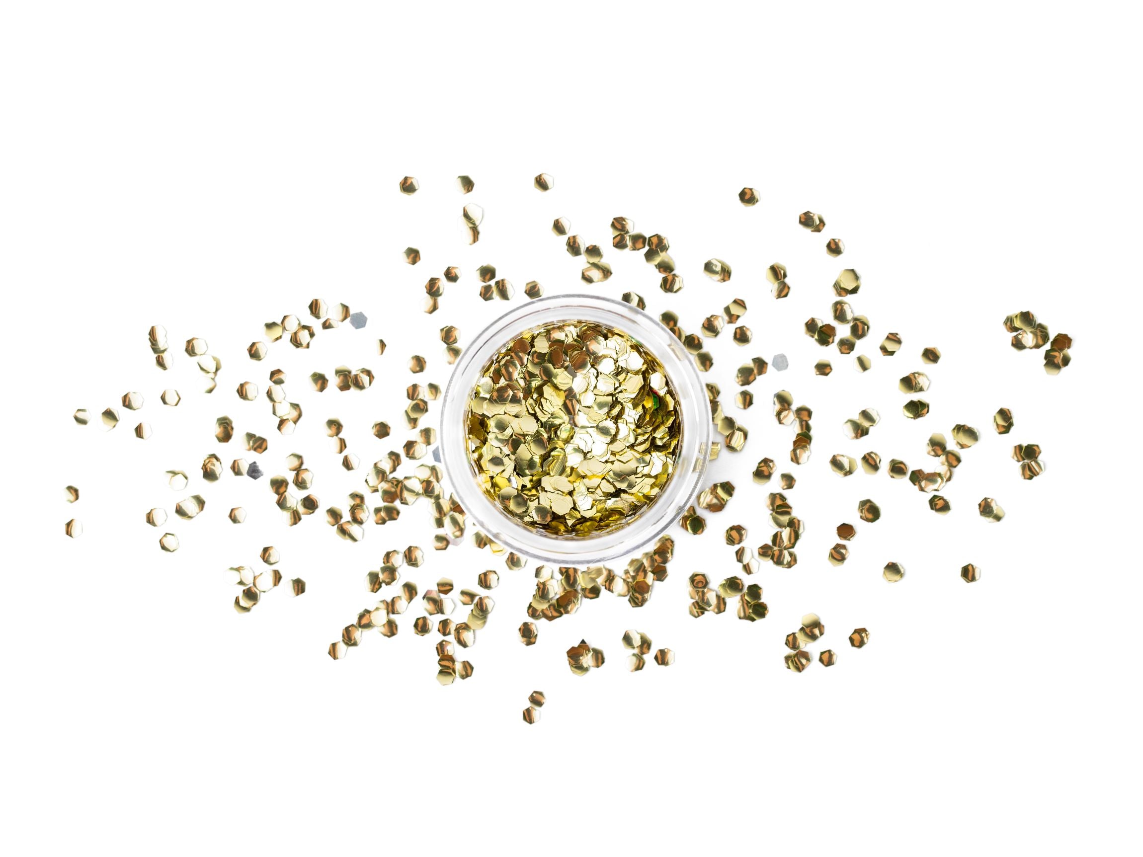 A clear jar filled with hexagonal gold glitter, with some of the glitter pieces scattered around the jar, against a white background.