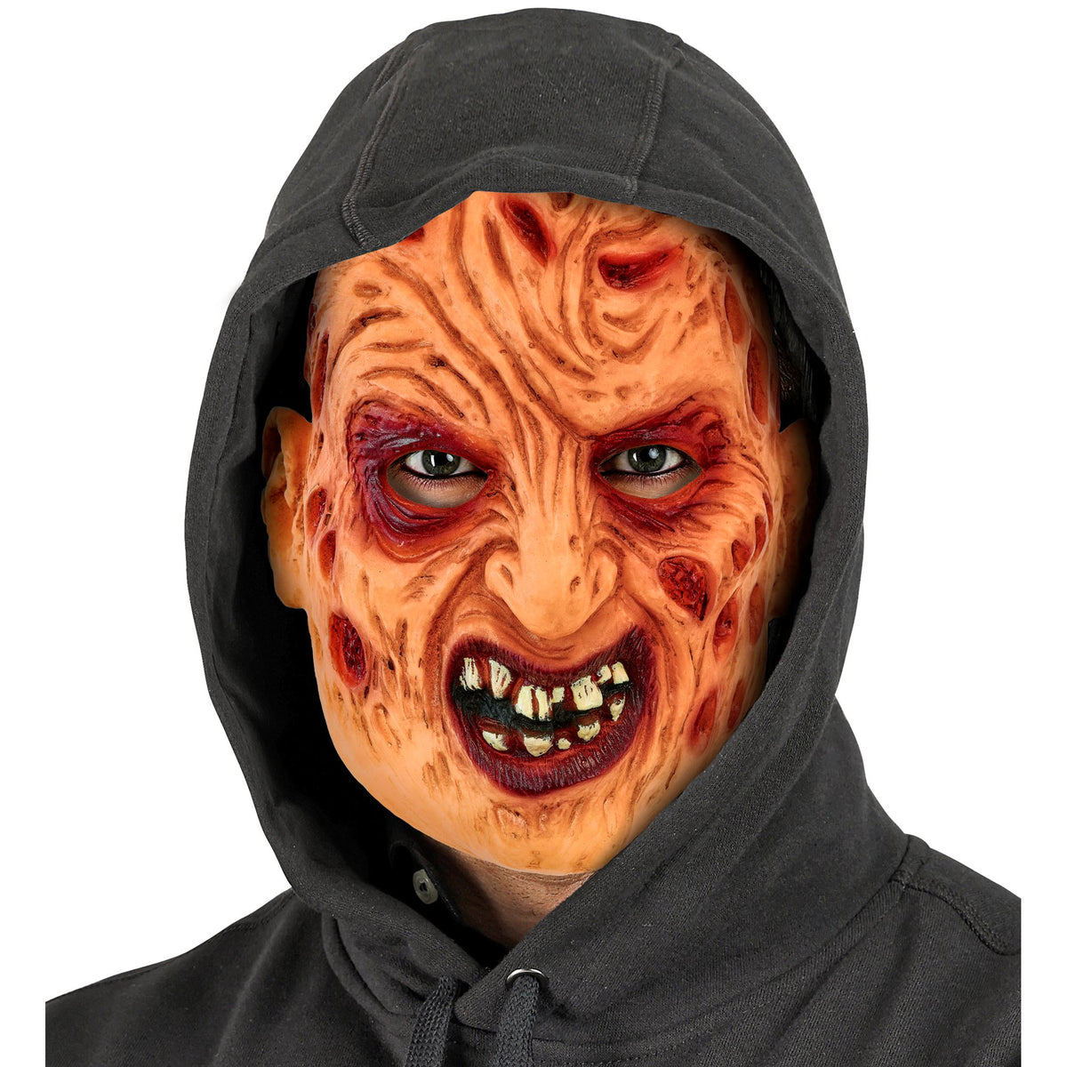 A person modeling the realistic 100% latex Freddy face mask featuring gruesome burn details and yellowed teeth, worn casually underneath a dark black hoodie.