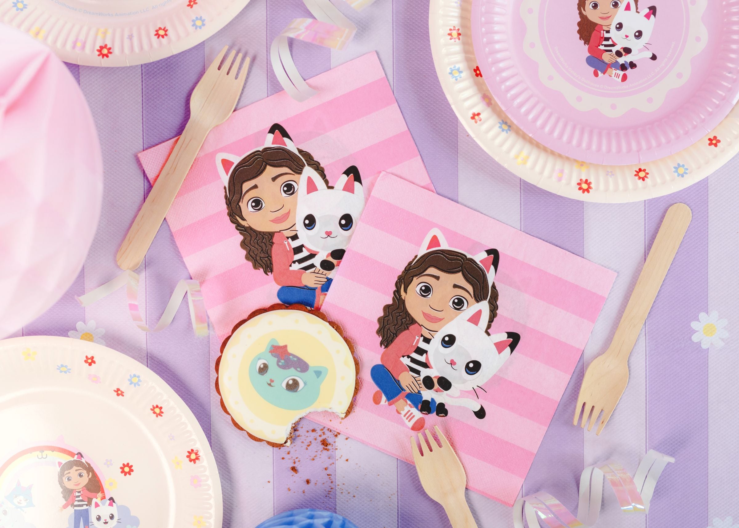 Children's Gabby's Dollhouse napkins and tableware set with cartoon characters on a striped background