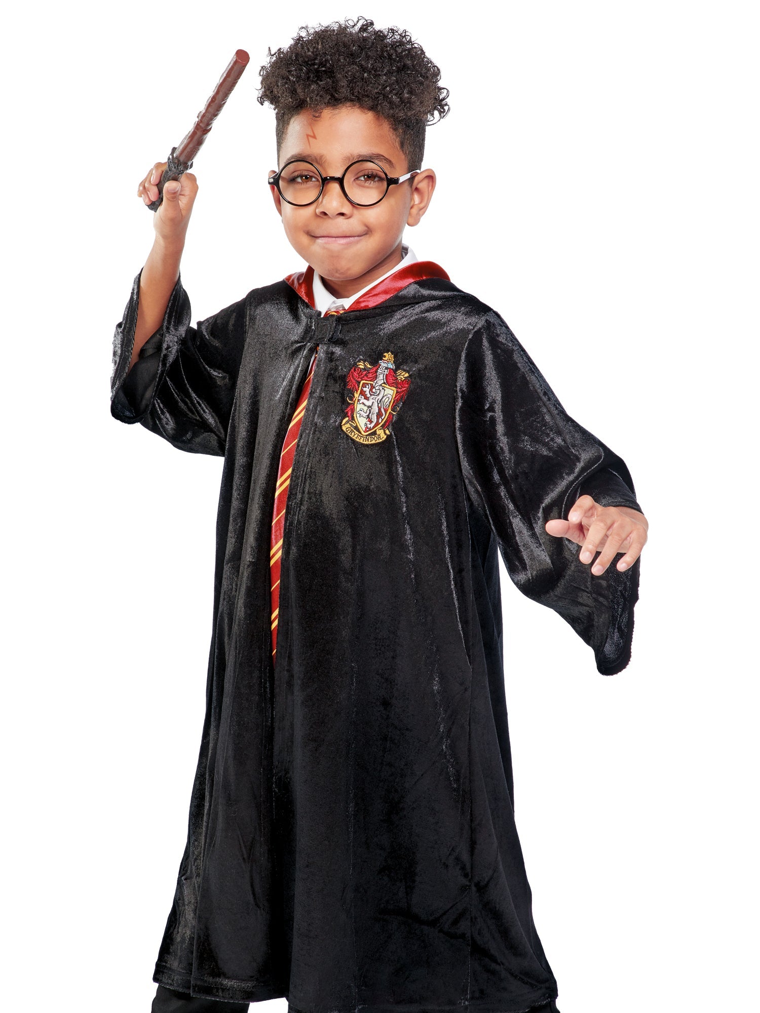 A young wizard posing with a wand in a deluxe Harry Potter costume robe.