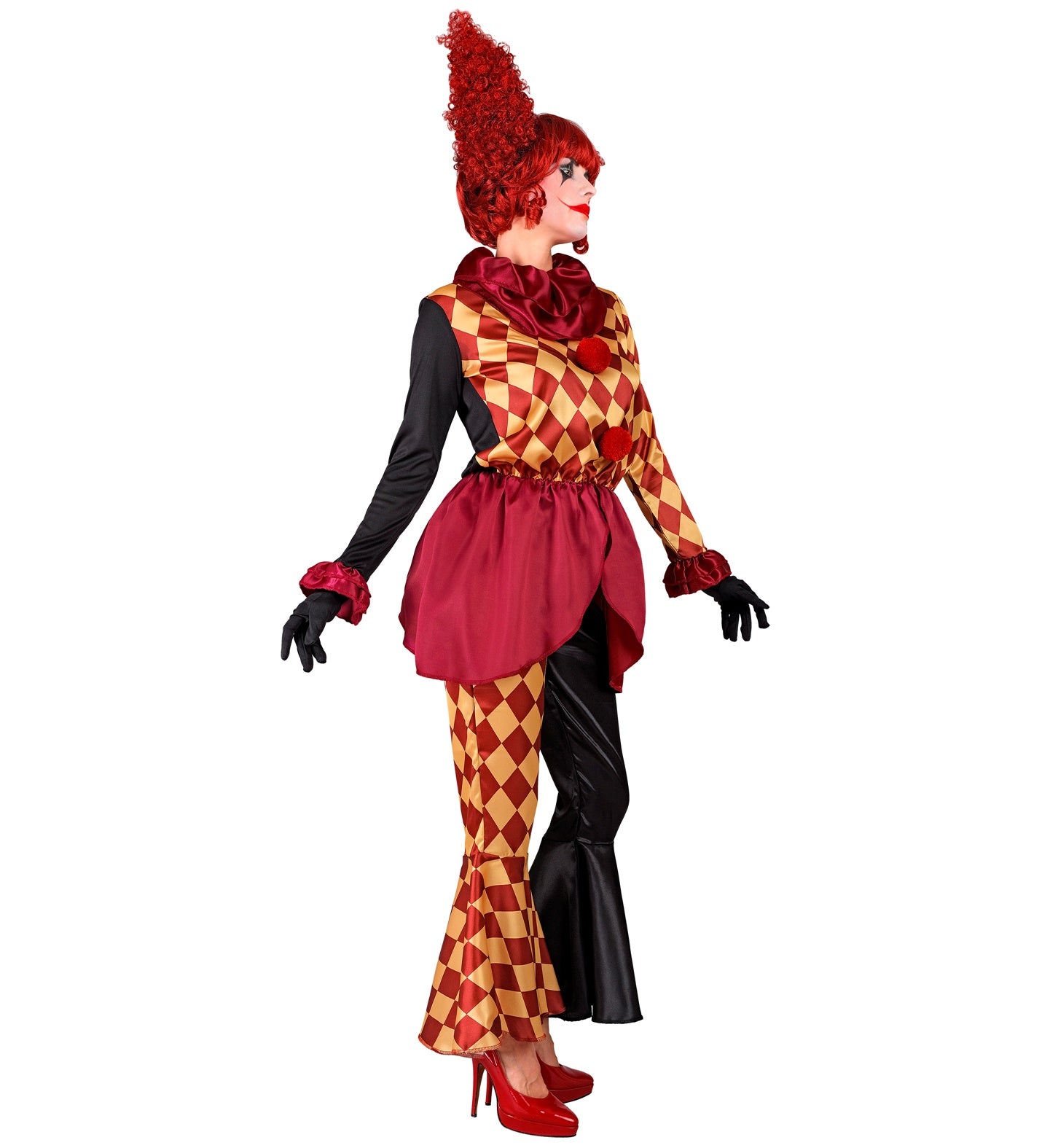 A side view of a woman in a colorful but creepy clown costume, posing with outstretched arms. The costume includes a ruffled neck collar, a coat with one black sleeve and one harlequin-patterned sleeve, and a pair of mismatched pants with one leg in a harlequin pattern and the other in black. The person is wearing a wild, curly red wig and has clown makeup on their face.