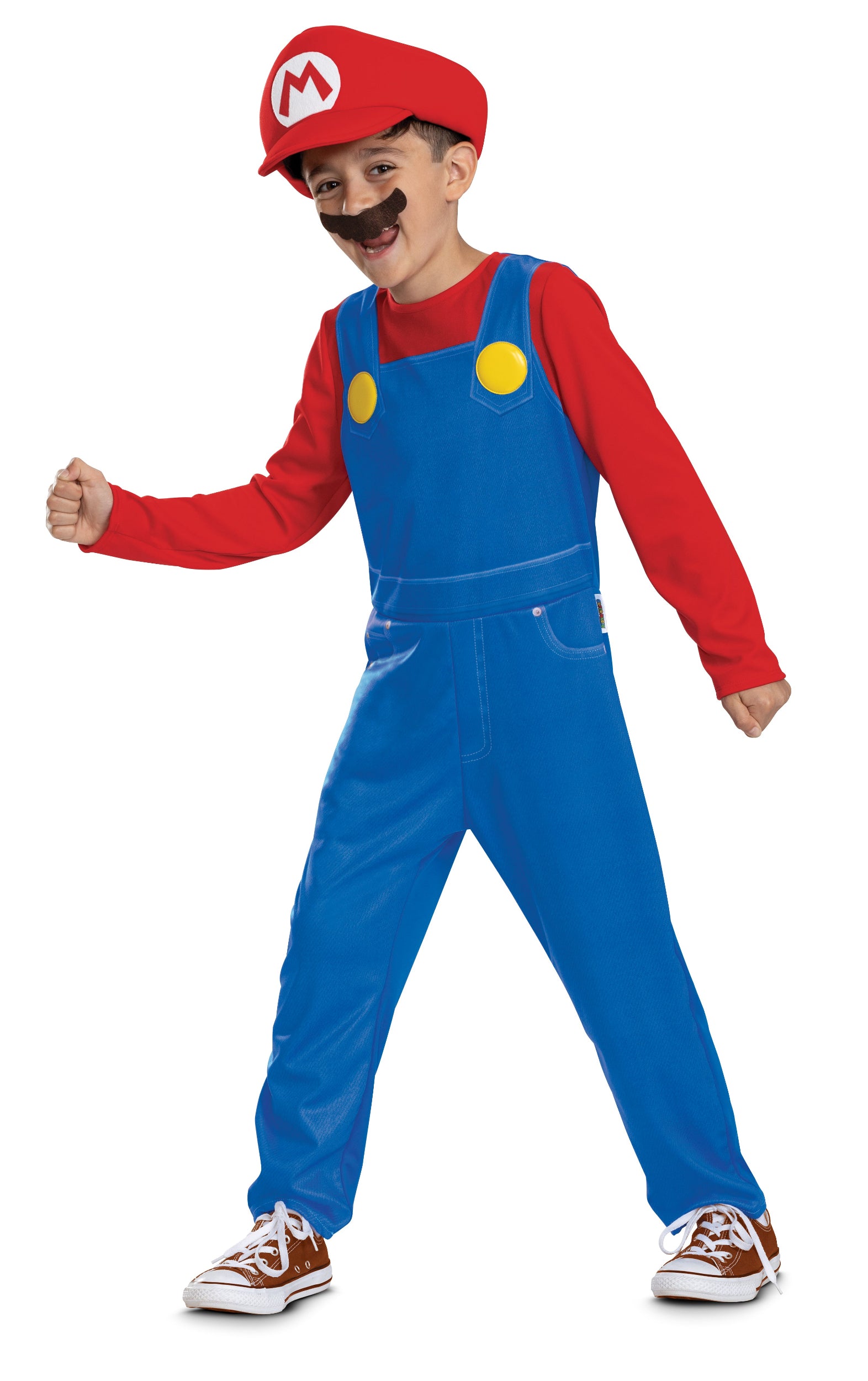 A boy wearing a Super Mario classic costume including a blue and red jumpsuit, iconic red hat, and moustache, standing in an energetic action pose.