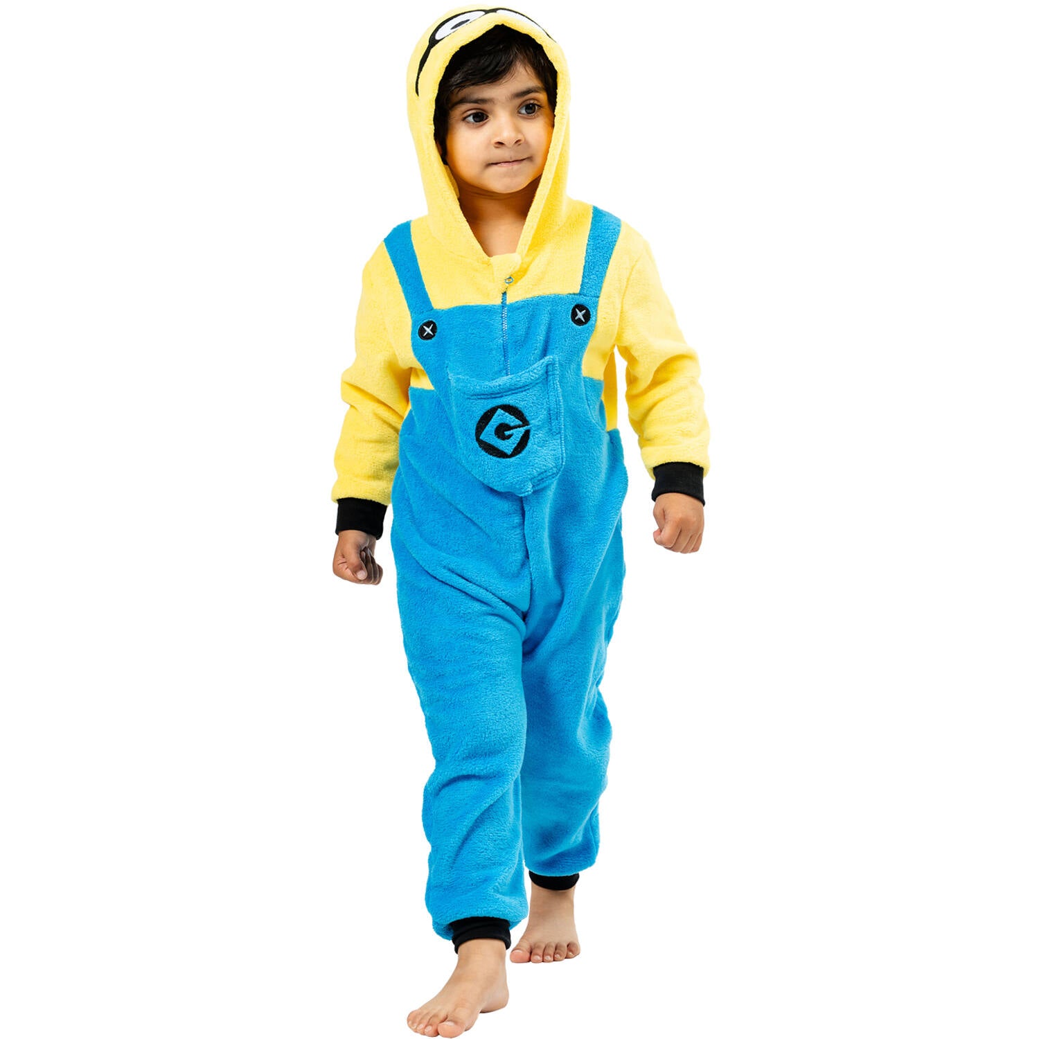 A child walking forward and modeling a soft yellow and blue hooded Minions onesie costume with faux denim overalls and black wrist cuffs.