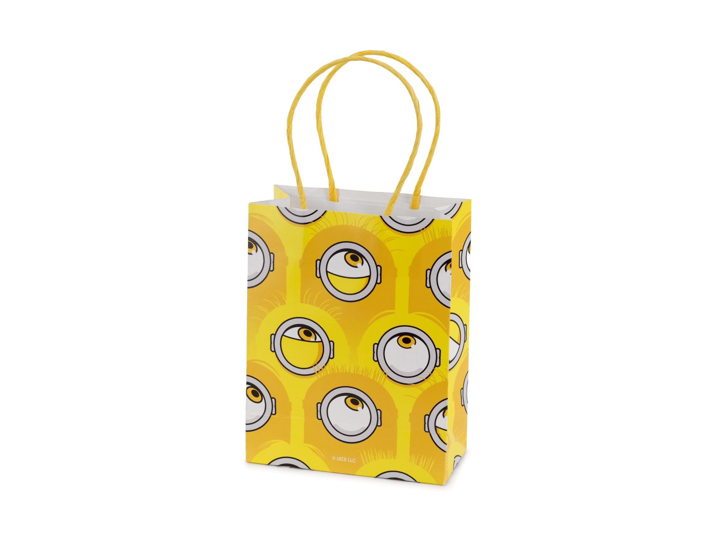 A bright yellow paper gift bag with twisted handles, featuring a playful all-over pattern of Minion eyes and silver goggles.