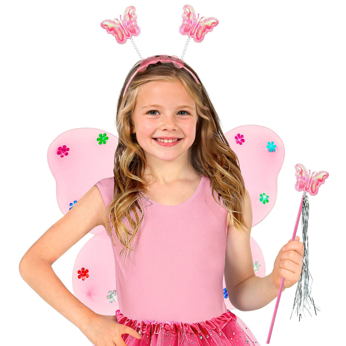 A young girl wearing a pink fairy costume with butterfly wings, a matching headband with butterfly decorations, and holding a butterfly wand, photographed against a solid white background.