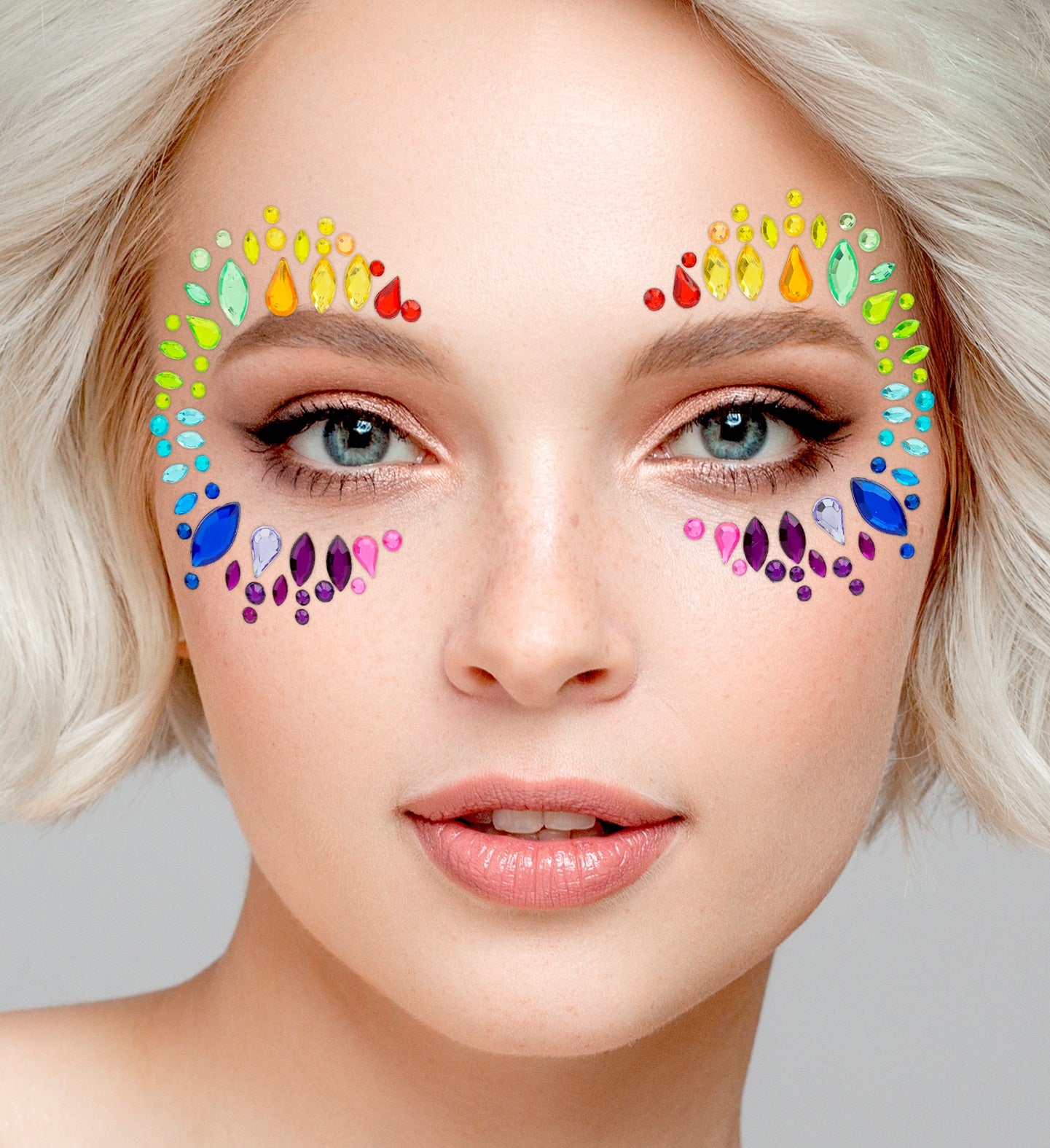 Close-up of multicolored face jewels applied around the eyes in a symmetrical rainbow pattern for a festive look.