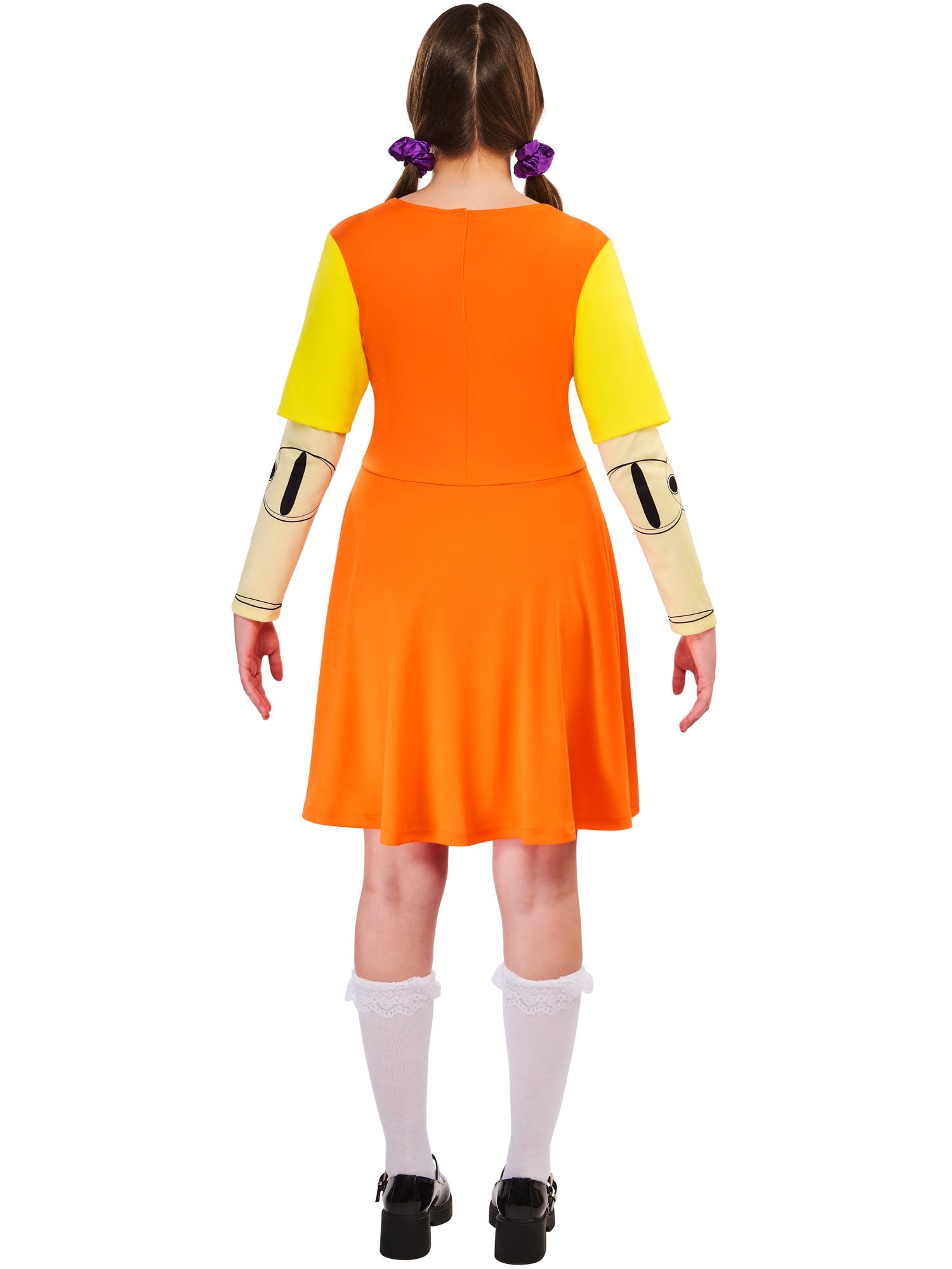 Back view of a woman wearing the orange and yellow Game Doll dress and white frilly socks, showing her pigtails.