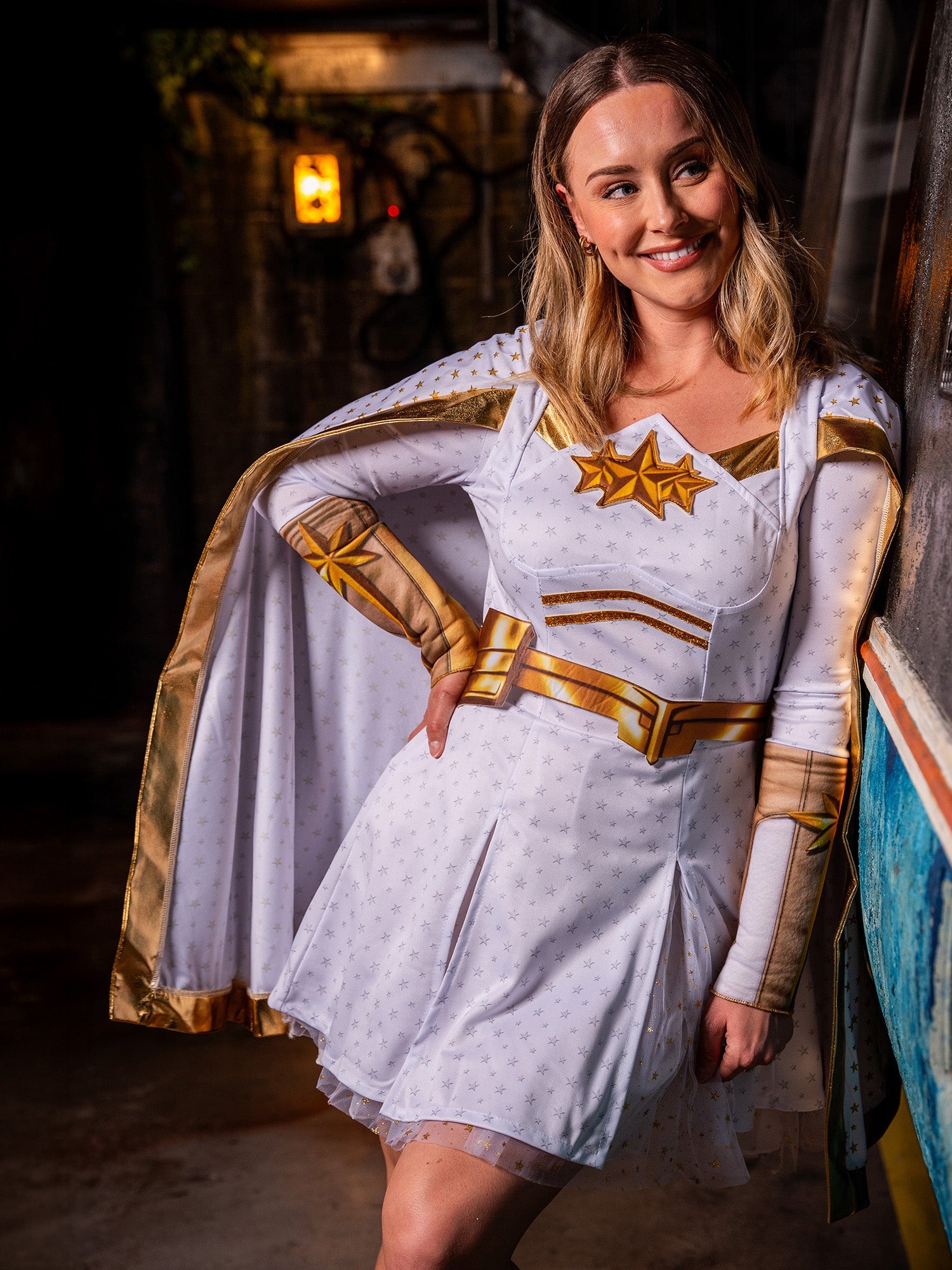 A woman in The Boys Starlight costume leaning against a wall, highlighting the white and gold star-themed details.