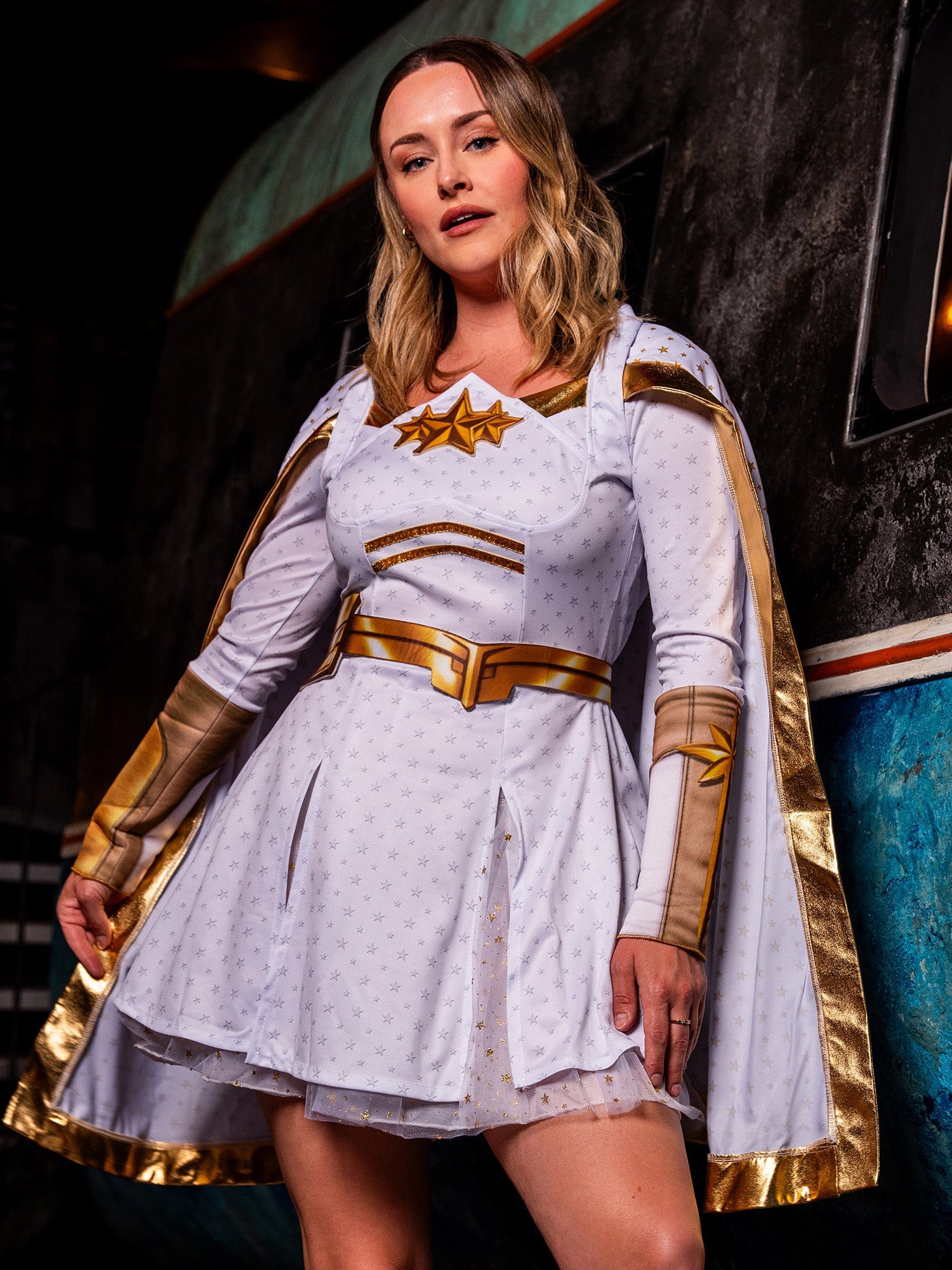 A woman in The Boys Starlight costume leaning against a wall, highlighting the white and gold star-themed details.