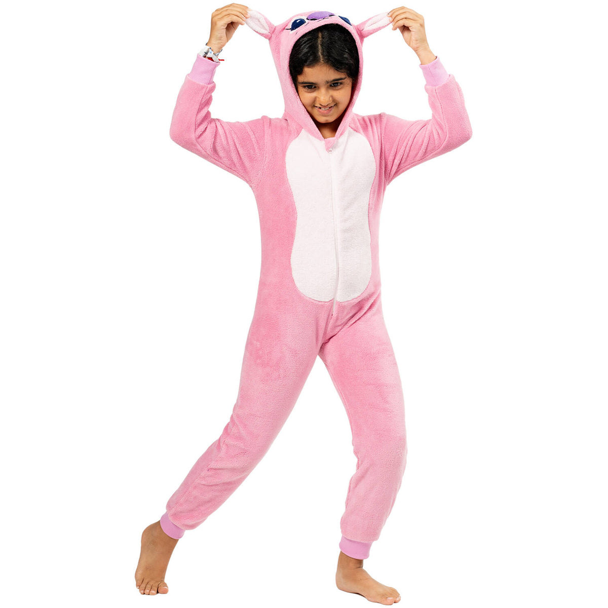 A young girl wearing a pink fluffy stitch Angel character onesie, smiling and holding up the soft ears on the hood.
