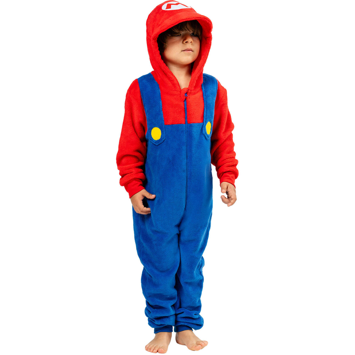 A young boy standing comfortably in the Super Mario hooded onesie, showcasing the built-in blue overalls, red shirt design, yellow buttons, and iconic 'M' logo on the hood.