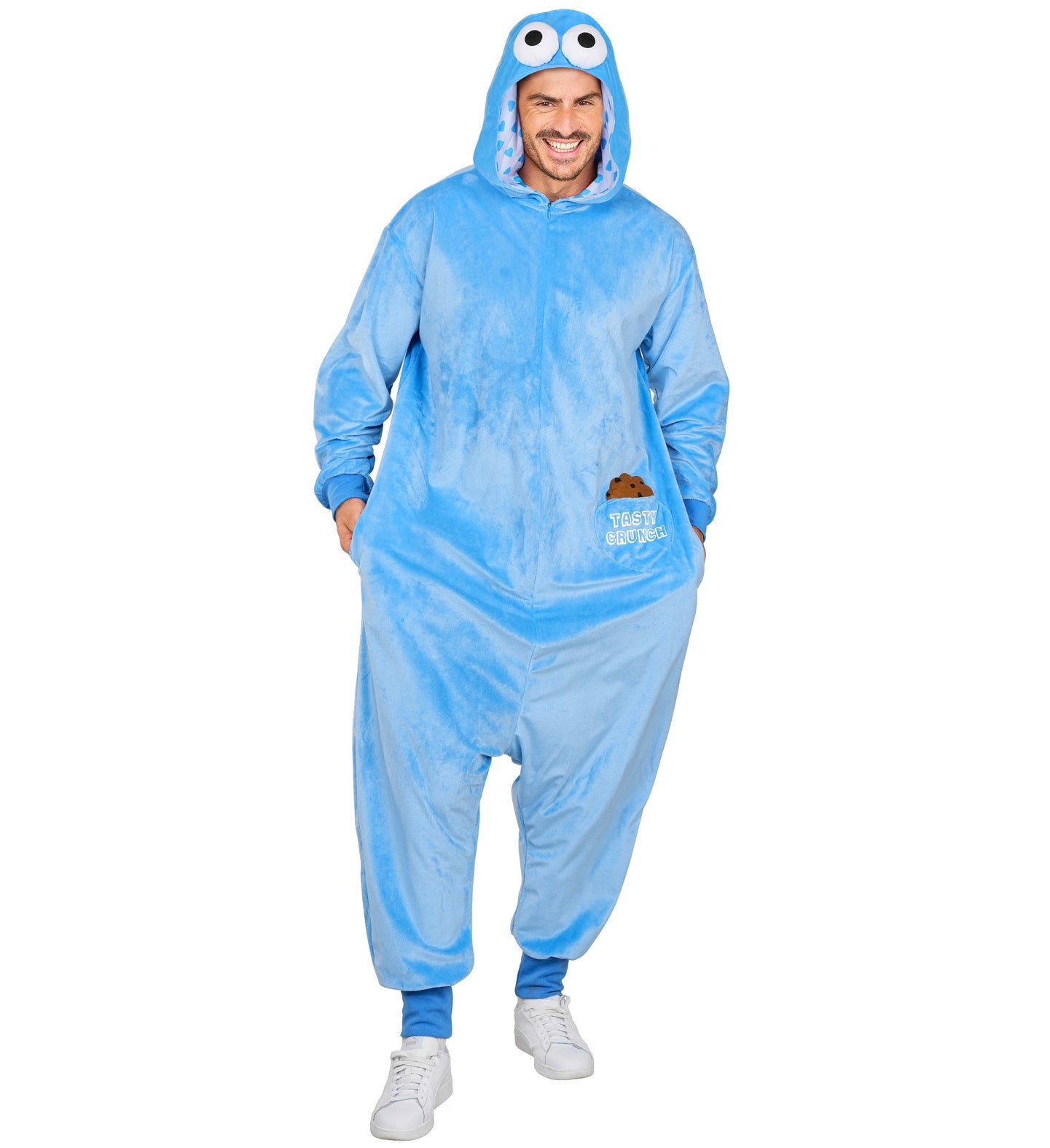 A man modeling the soft blue plush monster onesie with googly-eye hoods and cookie pockets.