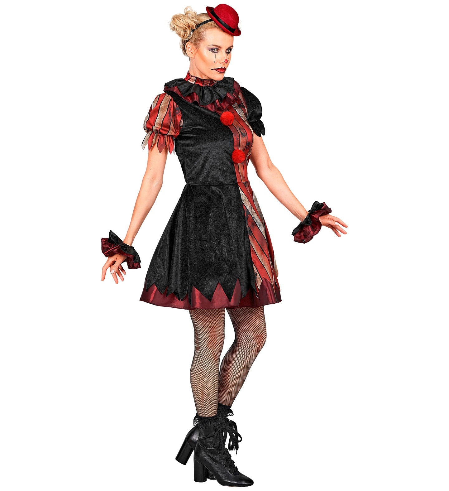 A full-length view of a blonde female model in a wicked clown costume featuring a jagged-hem dress, black fishnet tights, black lace-up boots, and ruffled wrist cuffs, looking off to the side with a menacing expression
