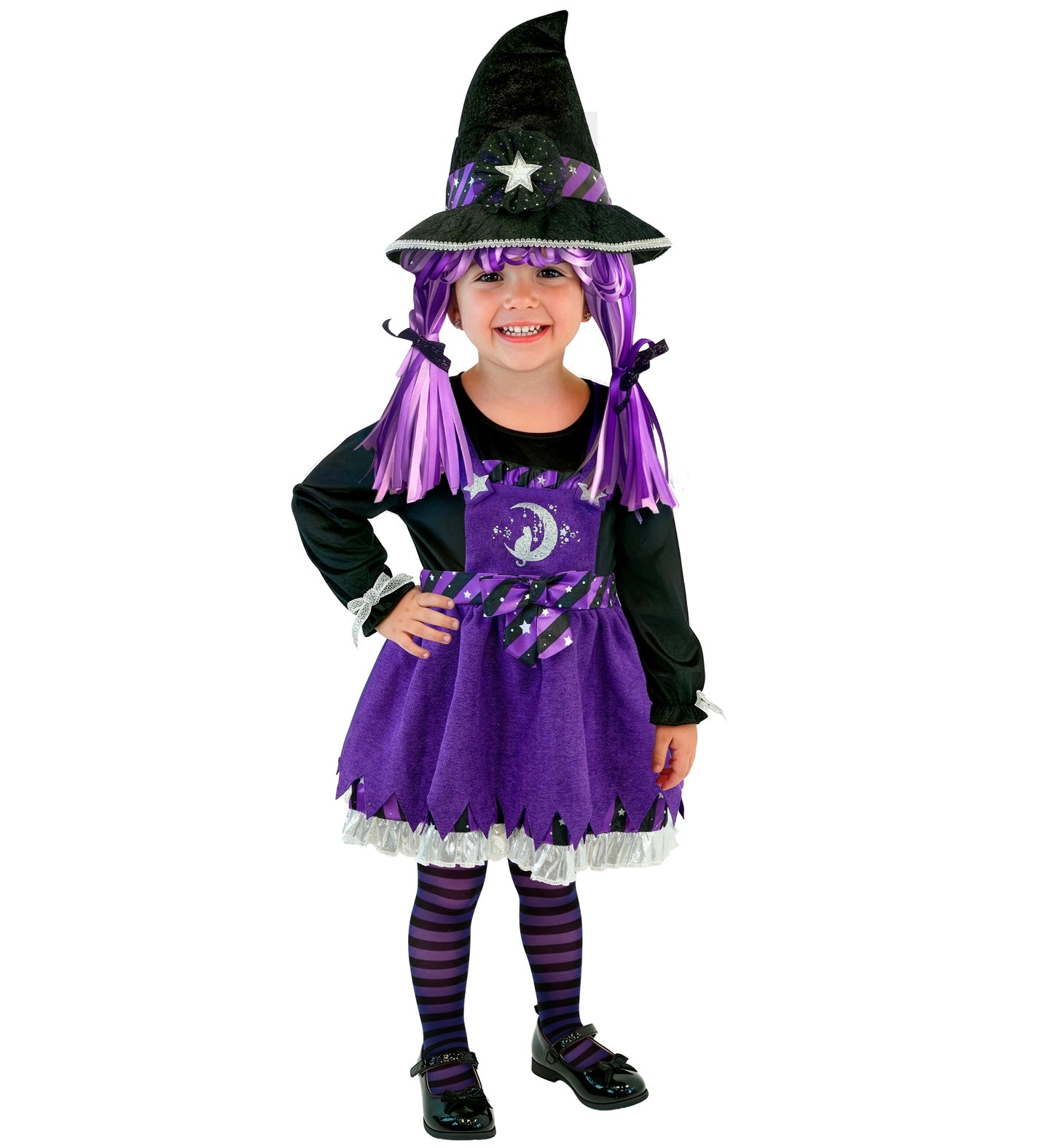 A happy toddler standing with one hand on her hip, modelling a vibrant purple and black witch fancy dress costume complete with a classic witch hat and purple ribbon pigtails.