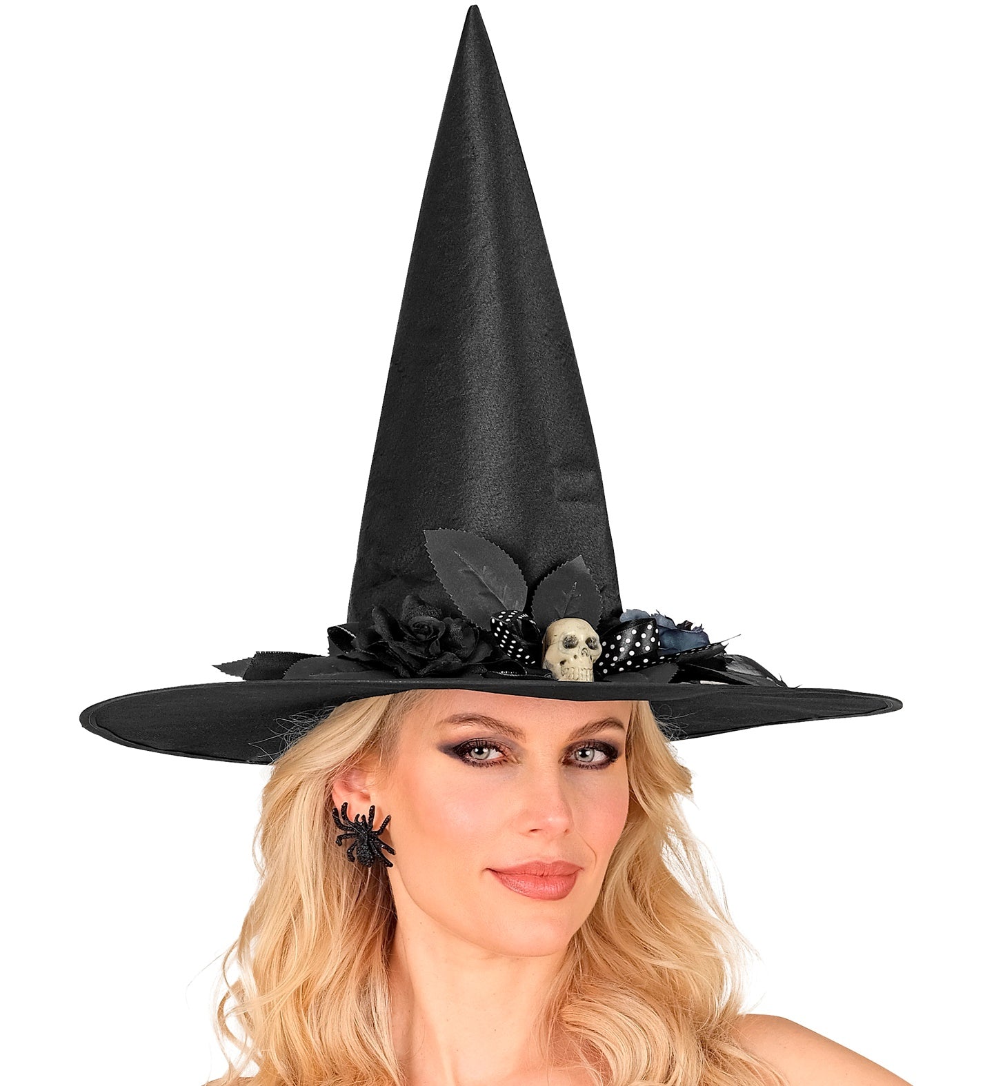 A close-up of a woman wearing a decorative black witch hat featuring a skull, a polka dot bow, and dark floral embellishments.