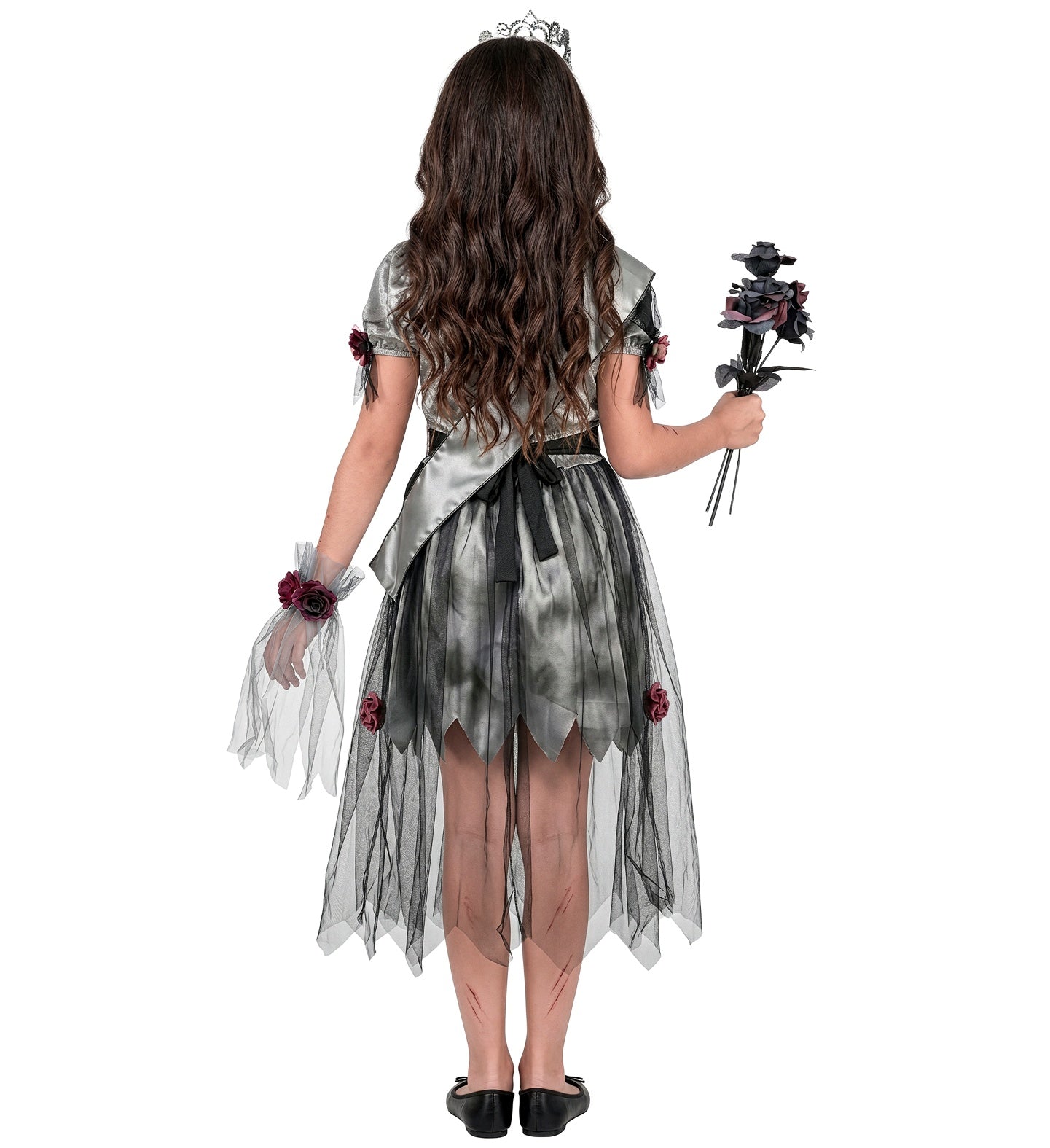 The back view of a young girl with long brown hair wearing a zombie prom queen fancy dress costume, showing the back of the grey satin bodice, a black waist tie, a silver sash, and a tattered black tulle skirt.