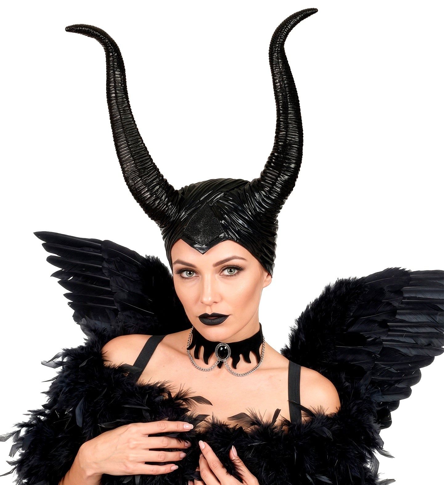 A model posing as a dark fairy wearing a glossy black horned headpiece, styled with massive black feathered wings, a black feather boa, and a black velvet choker.