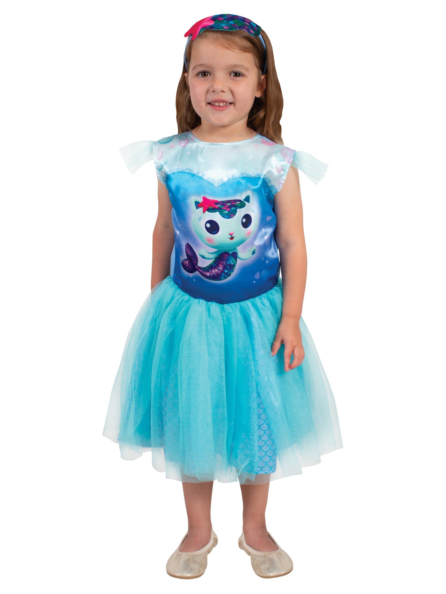 A young girl modelling a bright blue Gabby's Dollhouse Mercat fancy dress costume, featuring a printed bodice of Mercat with sheer flutter sleeves, a layered tulle skirt revealing a shiny mermaid scale pattern, and a matching starfish headband.