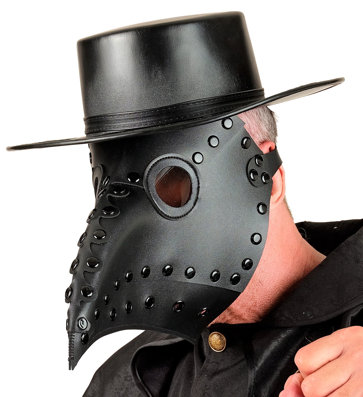 A side-profile view of a man wearing a studded black faux leather plague doctor mask with a matching black leather top hat over a high-collared shirt.