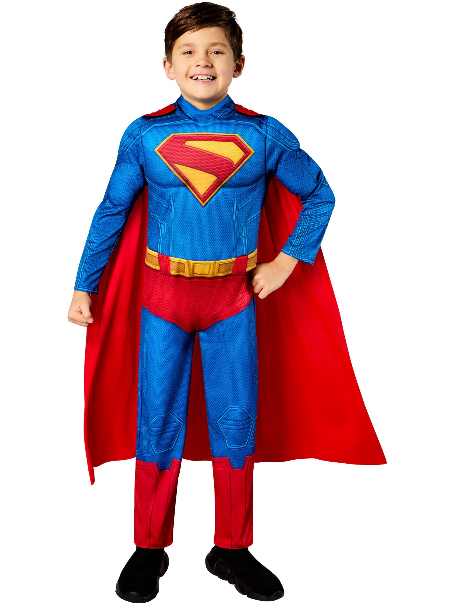 A child in a Superman costume, smiling, and posing heroically with hands on their hips, wearing the padded blue and red jumpsuit and a red cape.