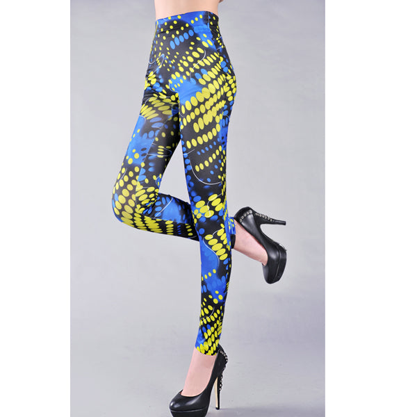 A pair of blue fashion leggings with an all-over polka dot print, displayed on a model without showing the upper part of the body.