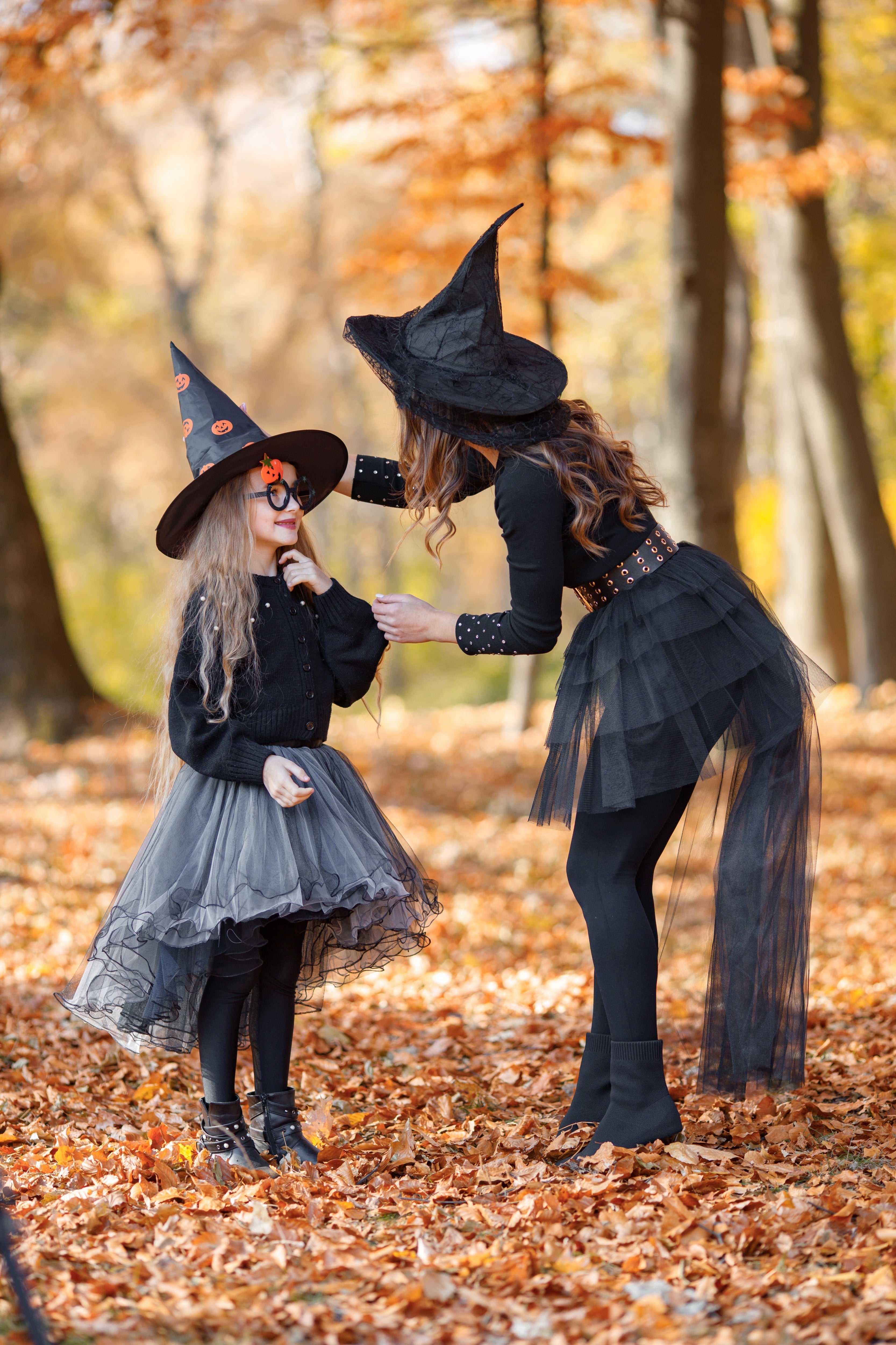 Mother and daughter dressed as witches playing in forest