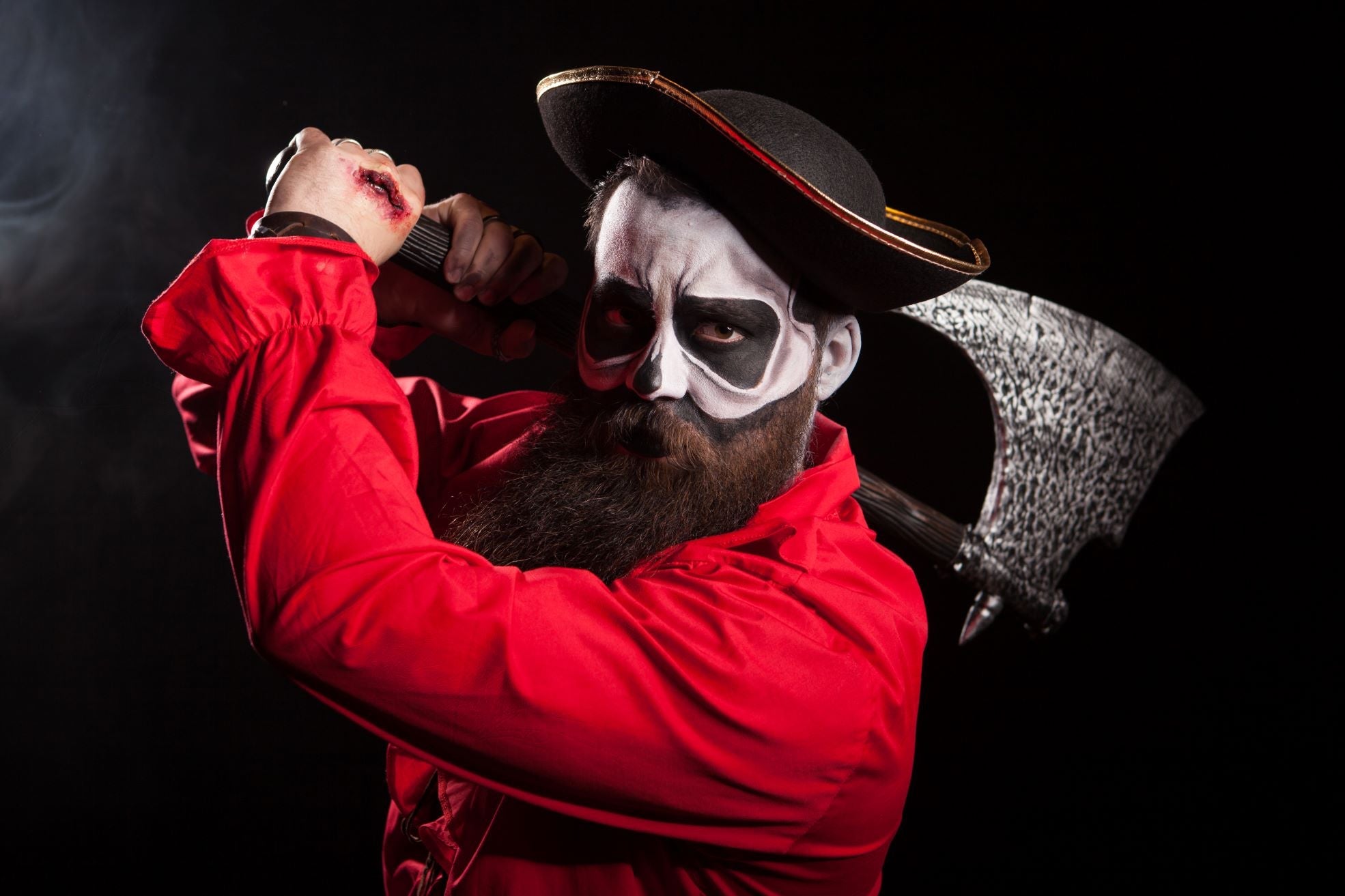 Man wearing a pirate costume holding an axe