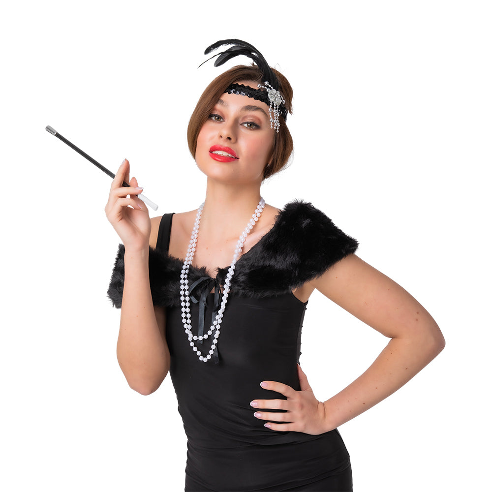 A woman wearing a 1920s black flapper accessory kit, including a feather headband, faux fur shawl, pearl necklace, and holding a prop cigarette holder.