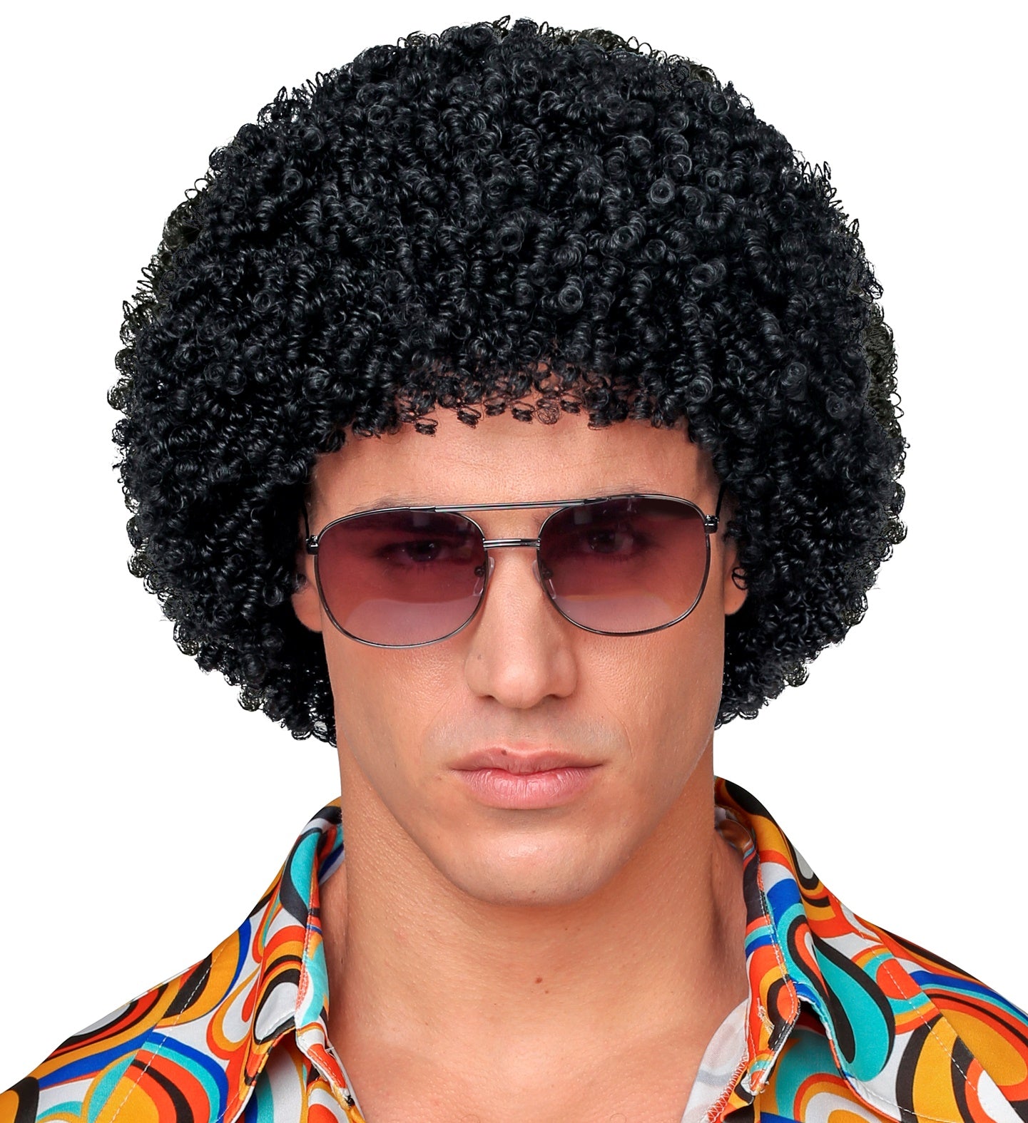 Man modelling a short black afro disco wig with retro aviator sunglasses and a psychedelic print shirt.