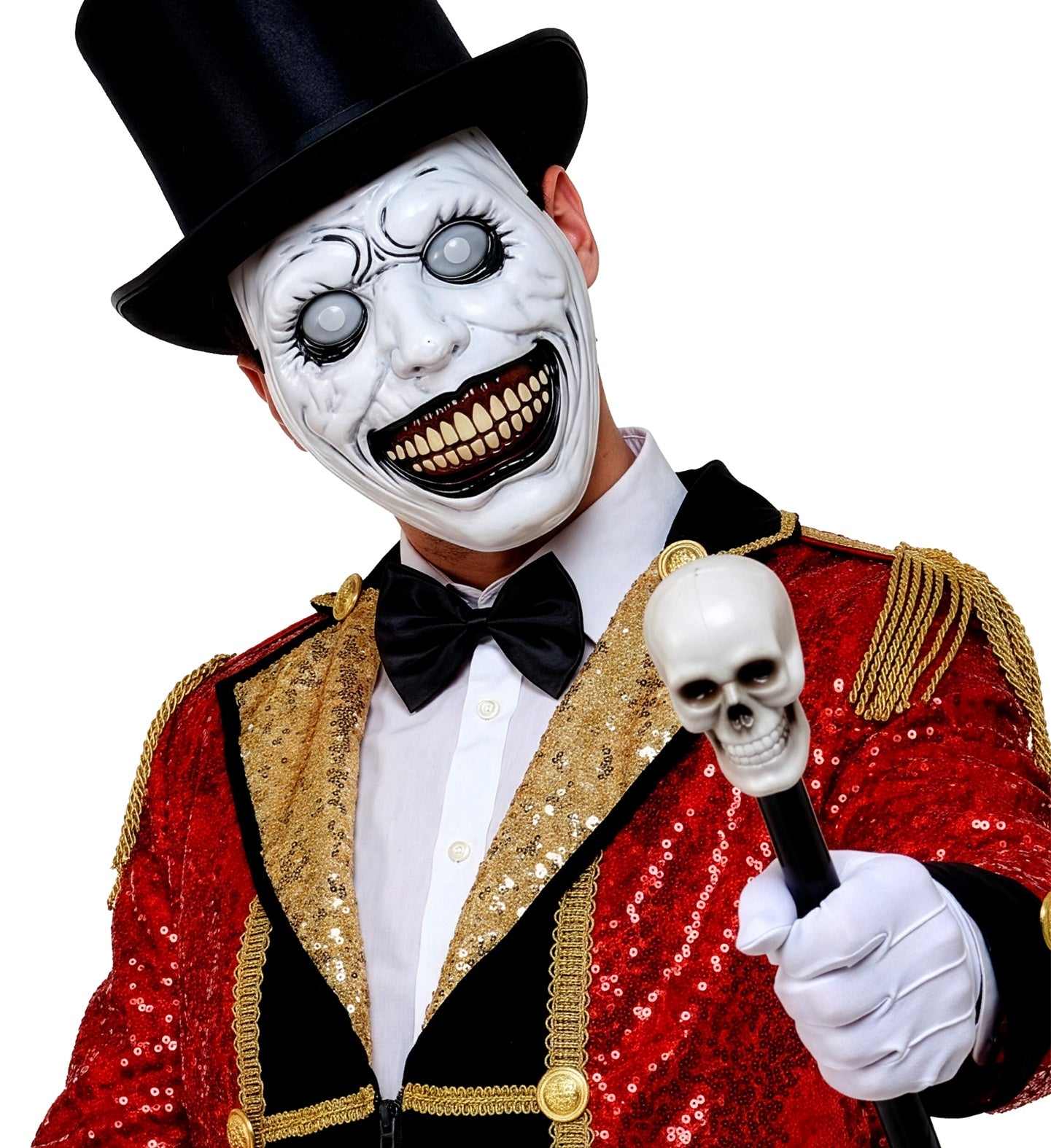 A model dressed as a creepy circus ringmaster in a red and gold sequin jacket and black top hat, holding a skull cane and wearing a terrifying white monster mask with a huge smile.