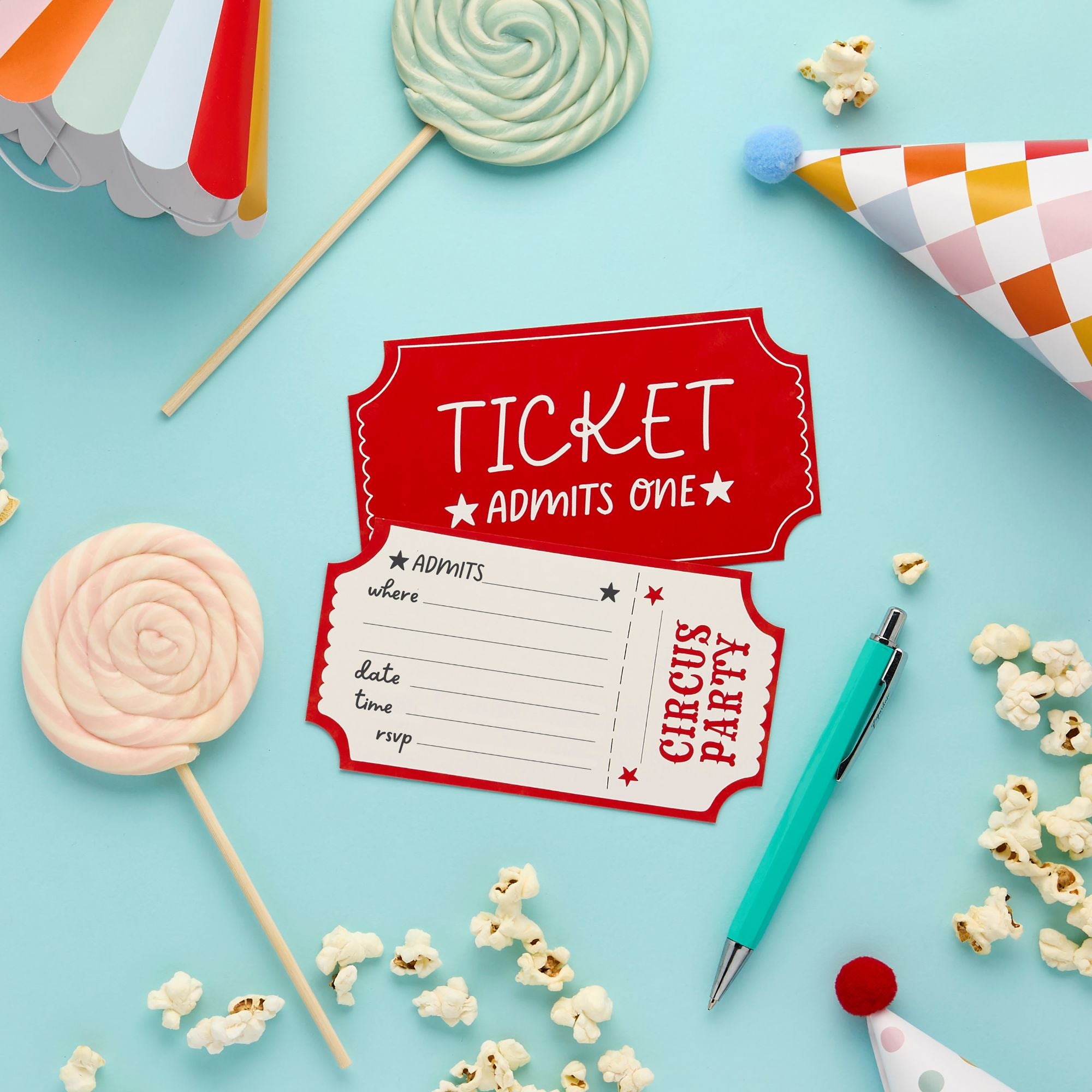 A ticket-style circus party invitation on a bright blue background surrounded by lollipops, popcorn, and party hats.