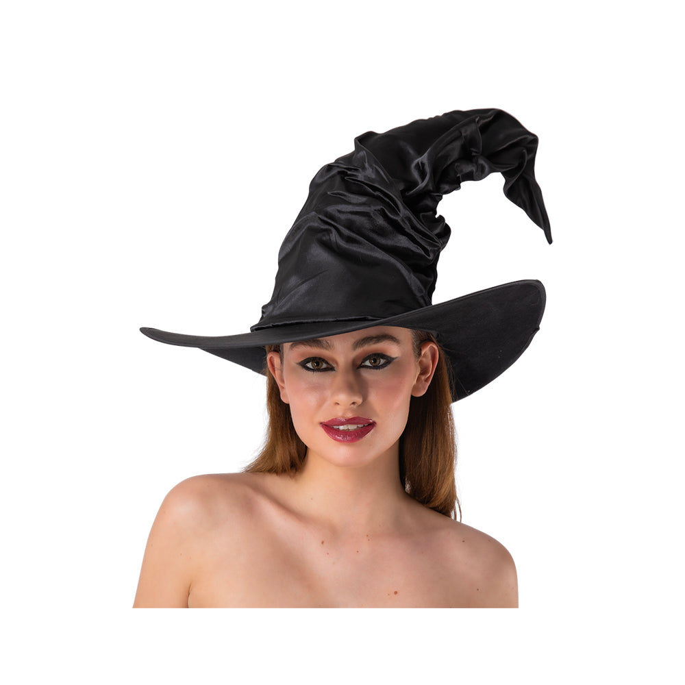 A person with dark hair and dramatic makeup, wearing a large, black, floppy witch hat with a crooked, slouchy crown, posing against a white background.