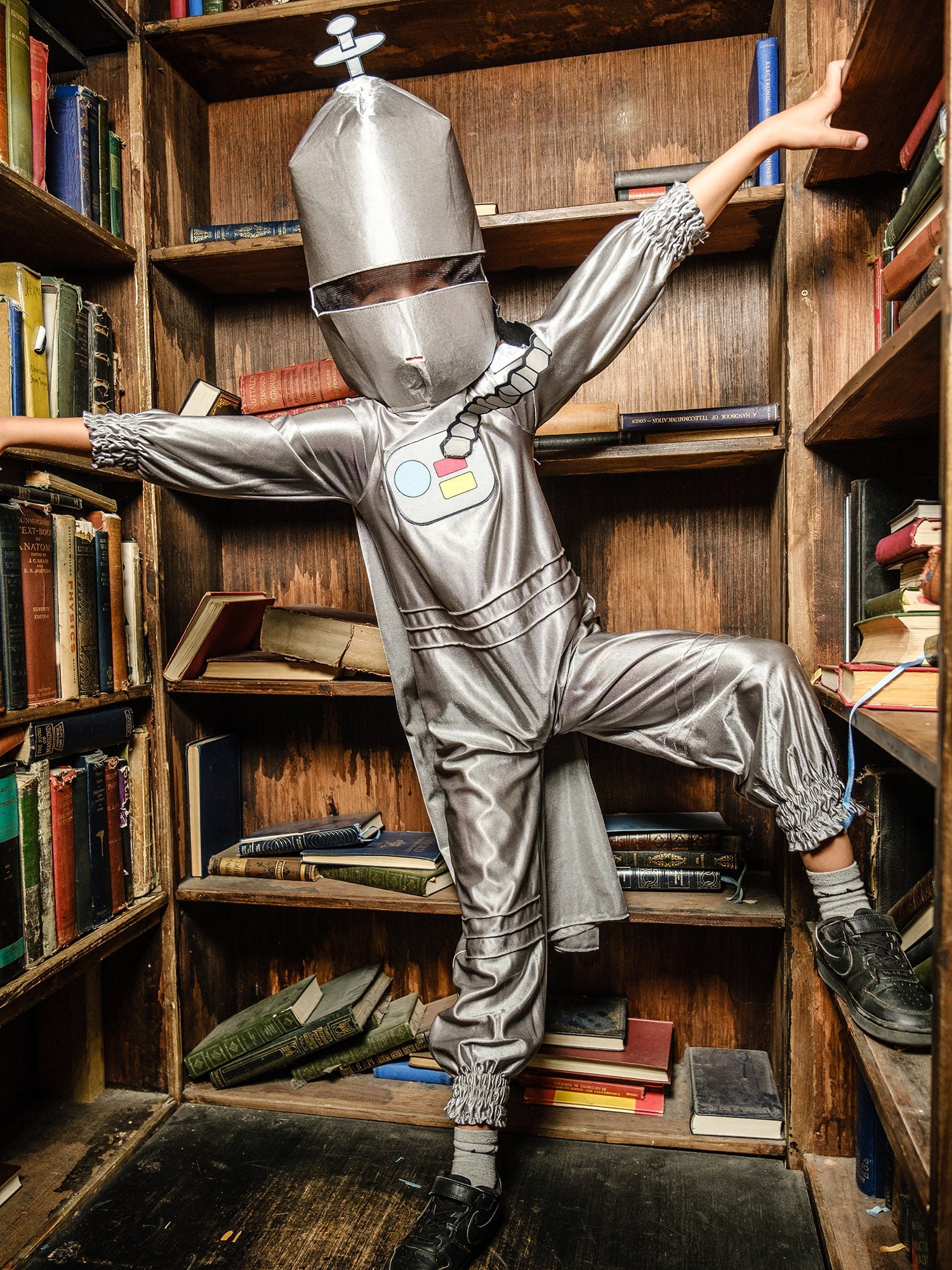 Little boy posing in a Spaceboy costume in front of a library bookshelf for World Book Day.