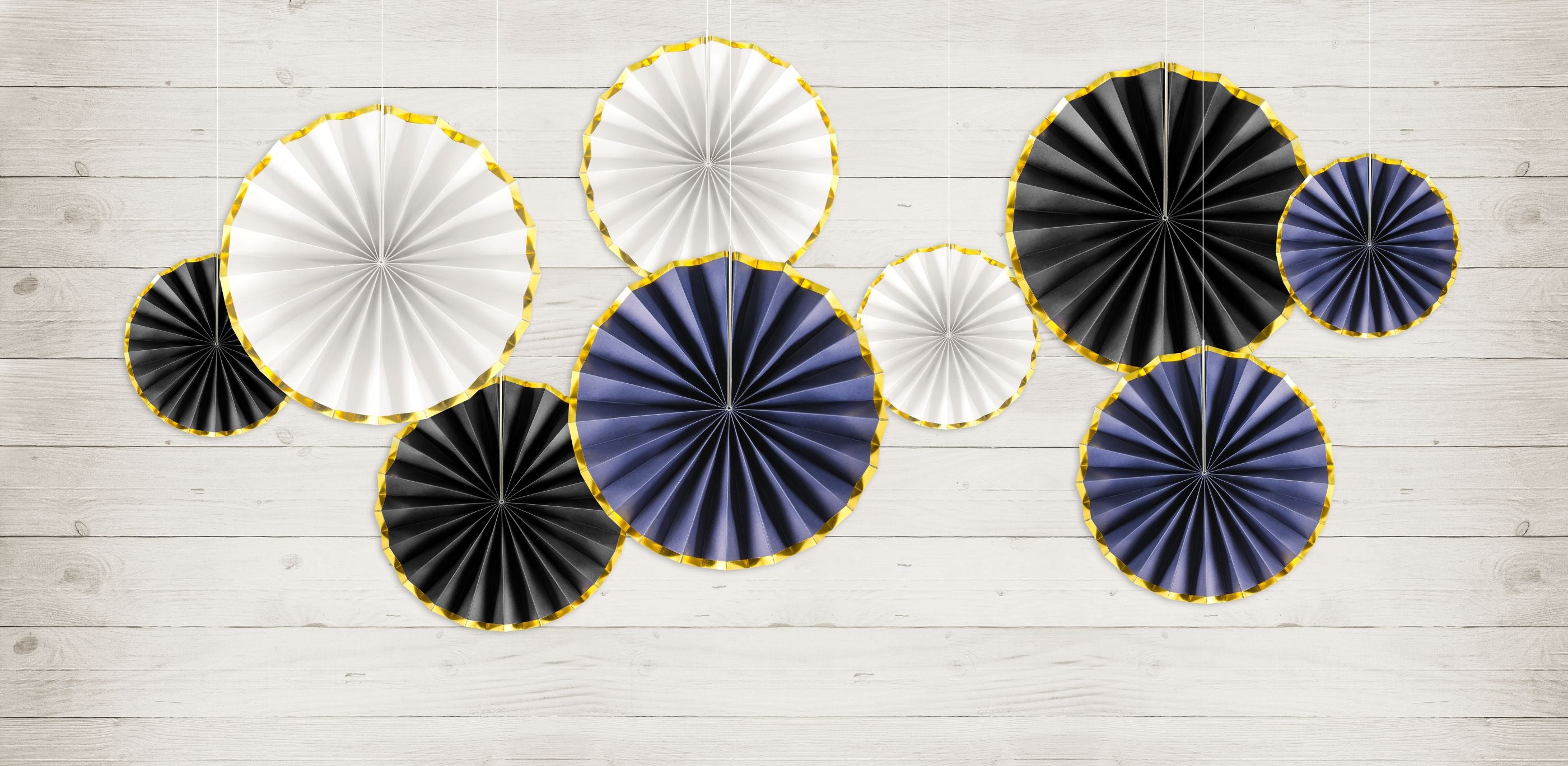 Blue, black and white fan rosettes with gold trim used to decorate a wall. 