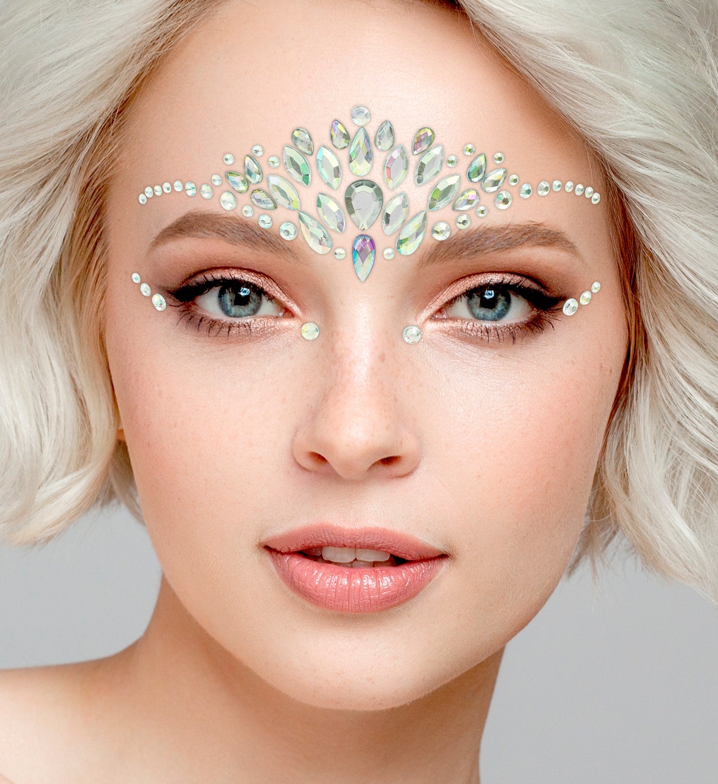 Close-up of a symmetrical crown-style face jewel arrangement in iridescent teardrop shapes.