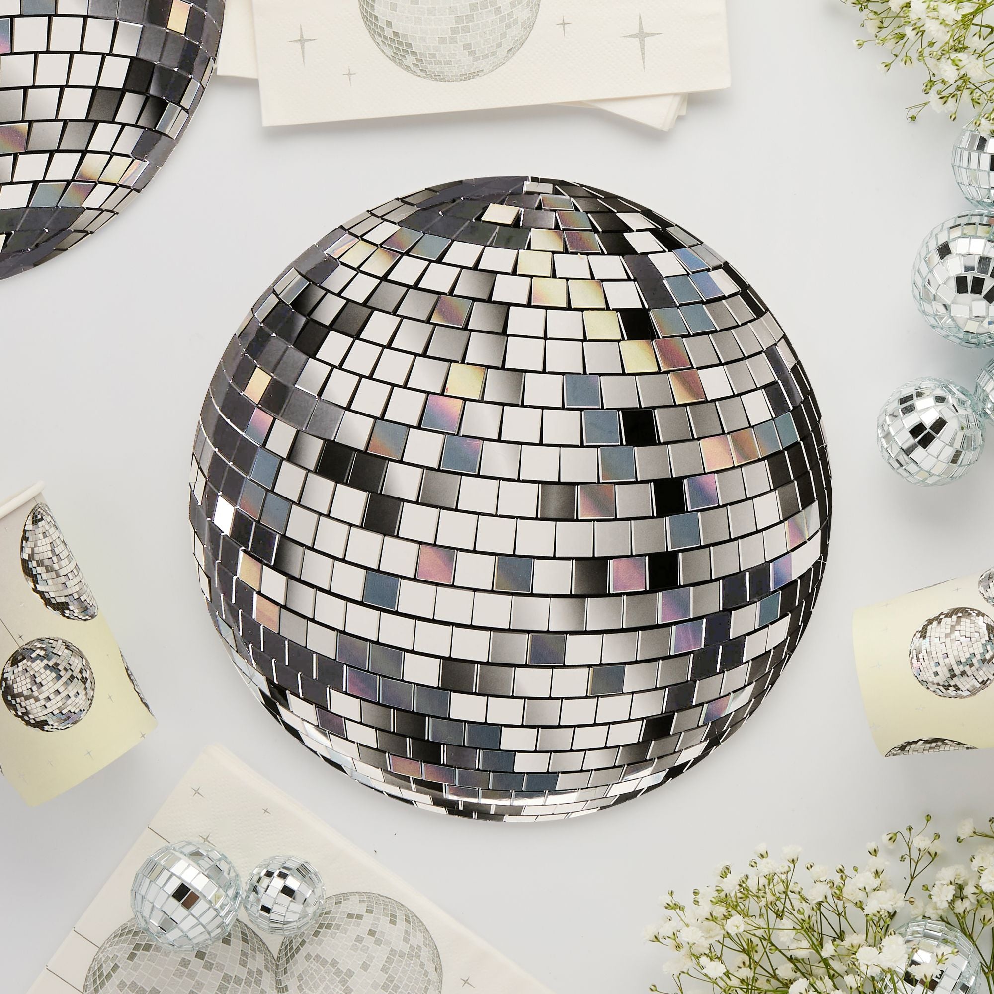 A close-up view of disco ball plates and small decorative mirror balls at a 70s themed party.