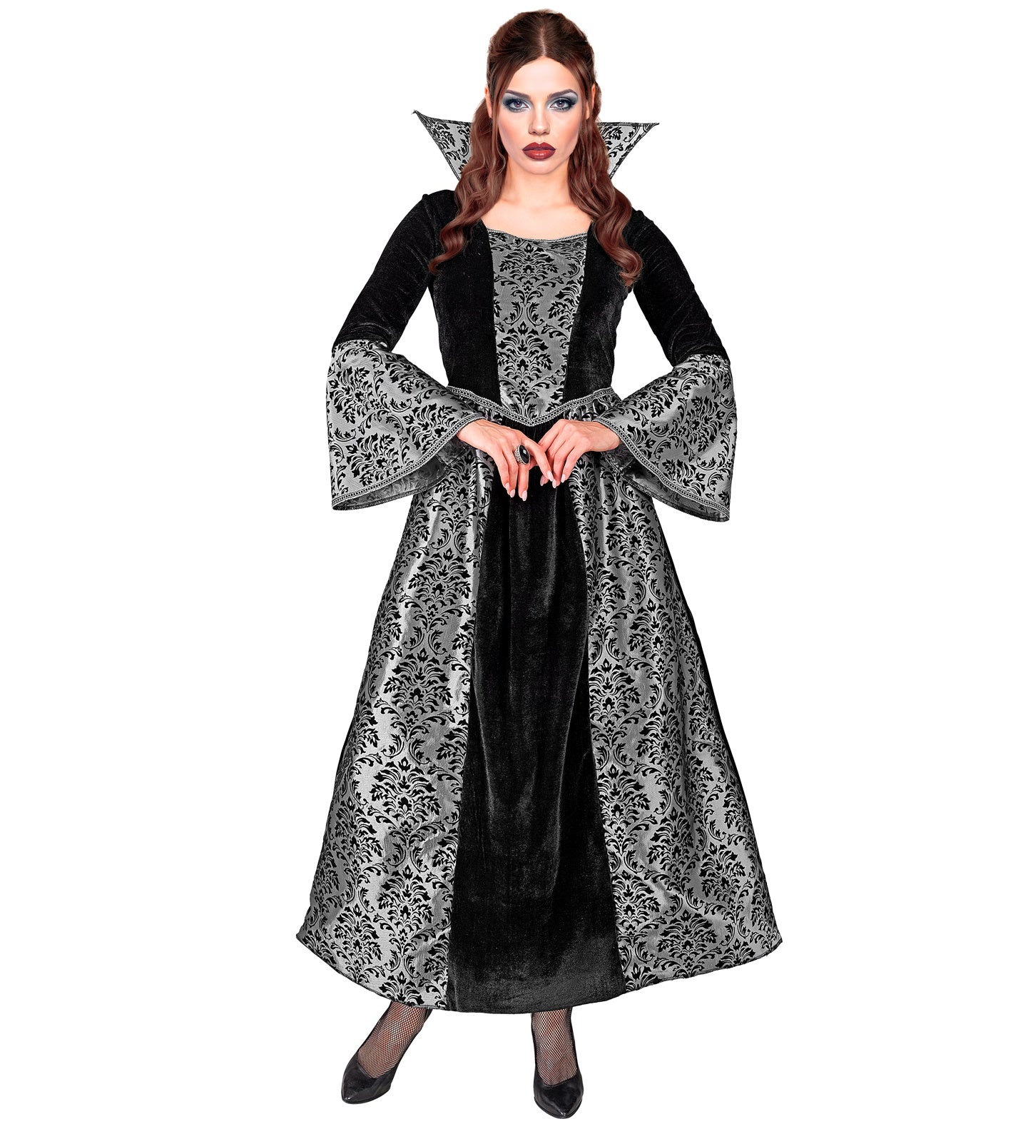 A woman in an elegant vampire costume, consisting of a full-length black velvet gown with a dramatic collar and silver damask patterned panels on the skirt and sleeves. The person is posing with hands clasped together in a graceful manner.
