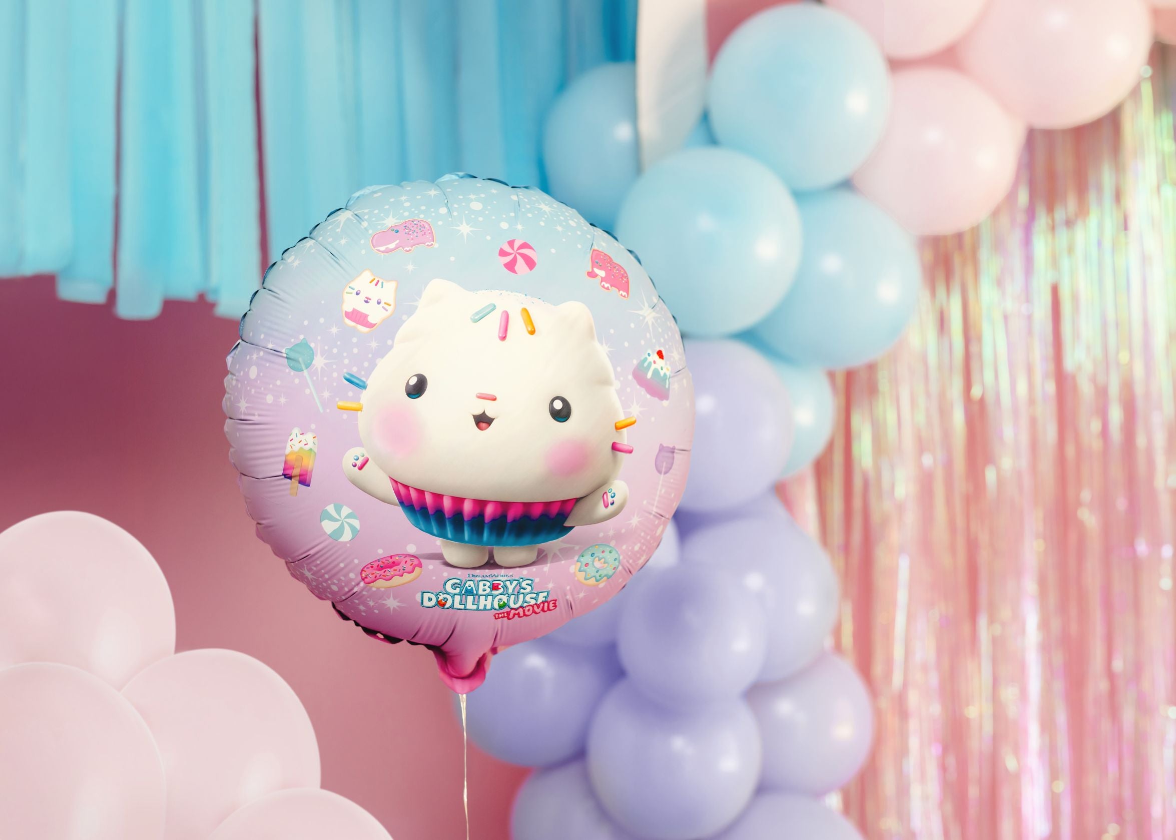 A Cakey Cat disc balloon floating beside colourful balloons.