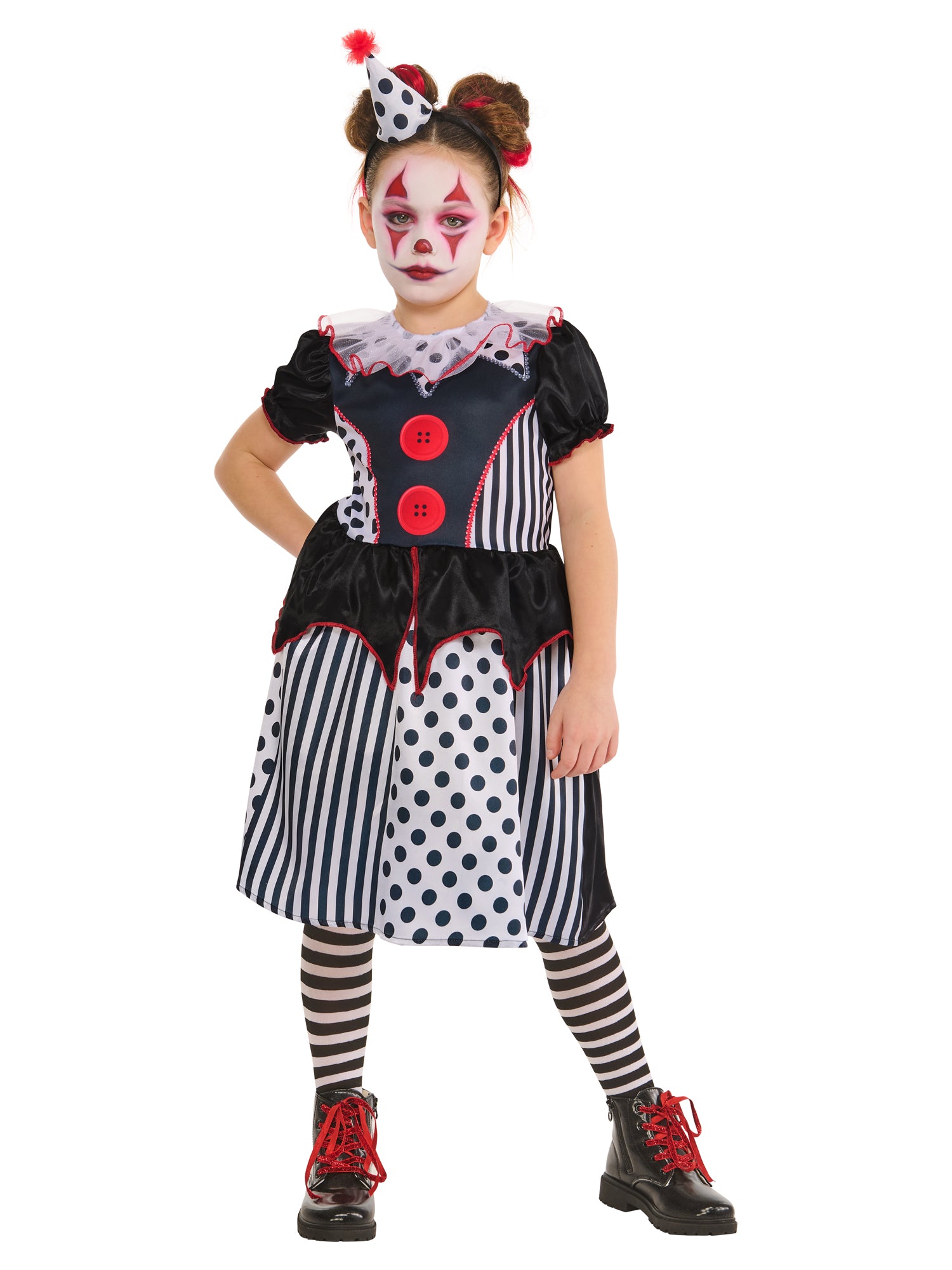 A child in a black and white clown costume, featuring a dress with a mix of polka dot and striped patterns, a ruffled collar, and red buttons. The child is wearing striped leggings and a headband with a small matching clown hat, standing with one hand on her hip, against a white background.