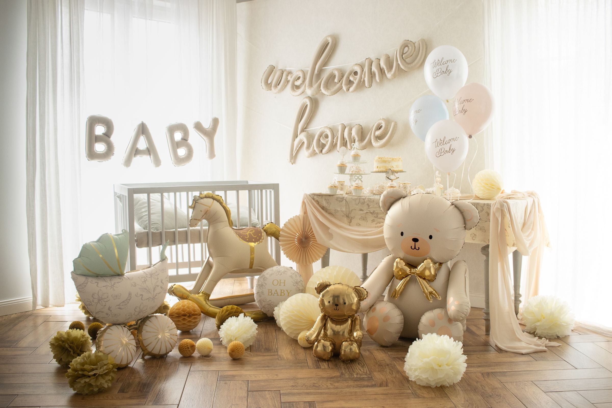 A gold rocking horse foil balloon standing next to a white baby crib in a decorated nursery with other balloon ideas.